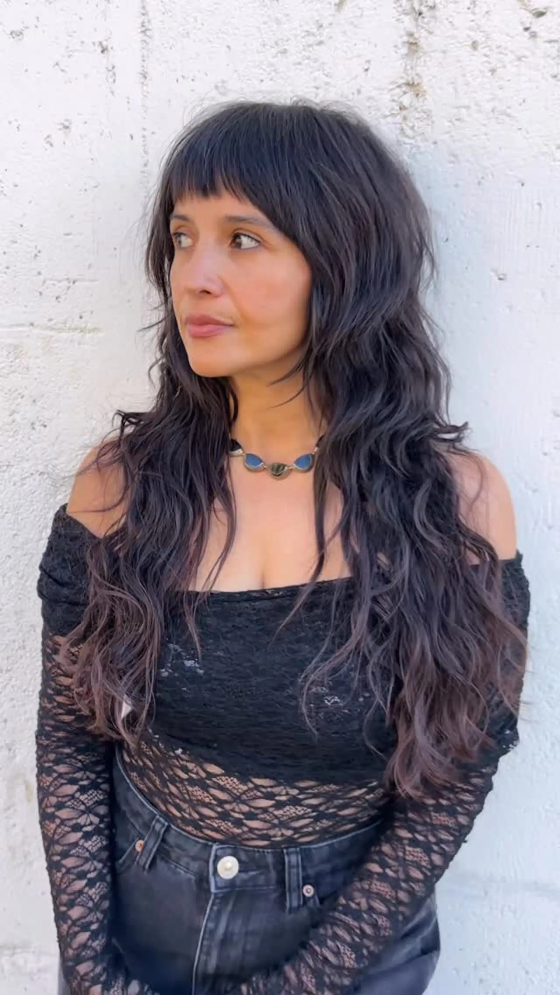 A textured long shag haircut with piecey curtain-style fringe bangs and natural, tousled waves. 1