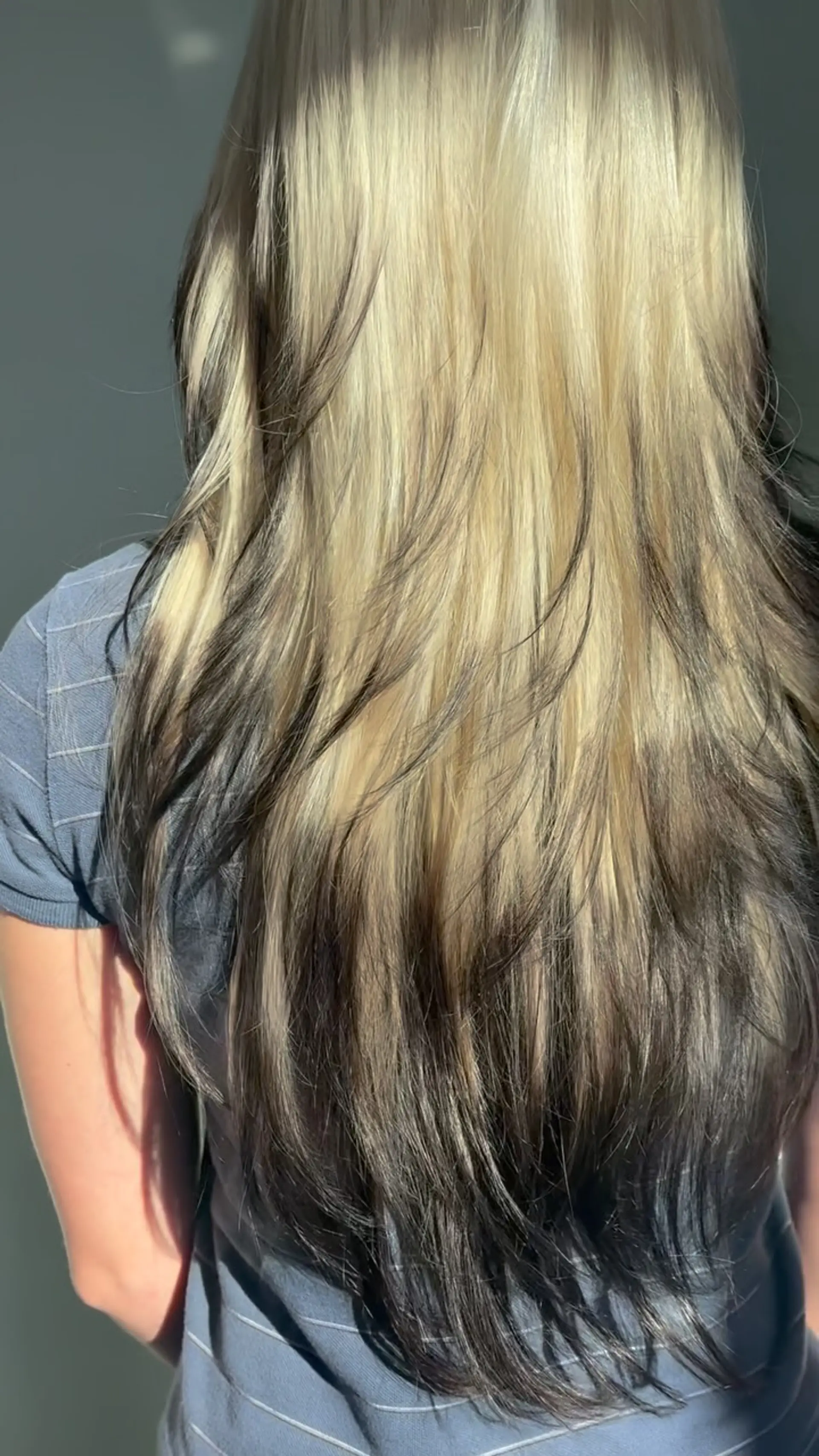 Long, layered platinum blonde hair styled with high-contrast dark ends and feathered, wispy framing. 1