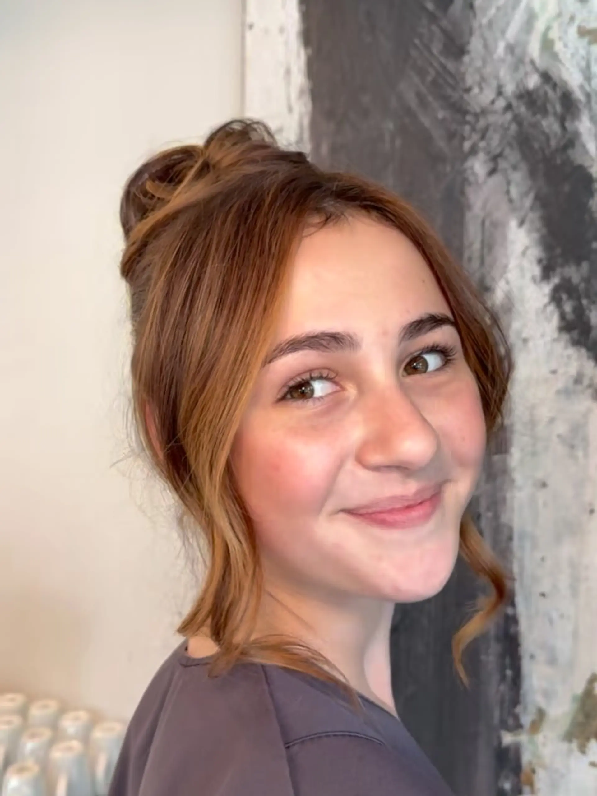 A sophisticated high updo styled with soft, wavy face-framing tendrils. 1