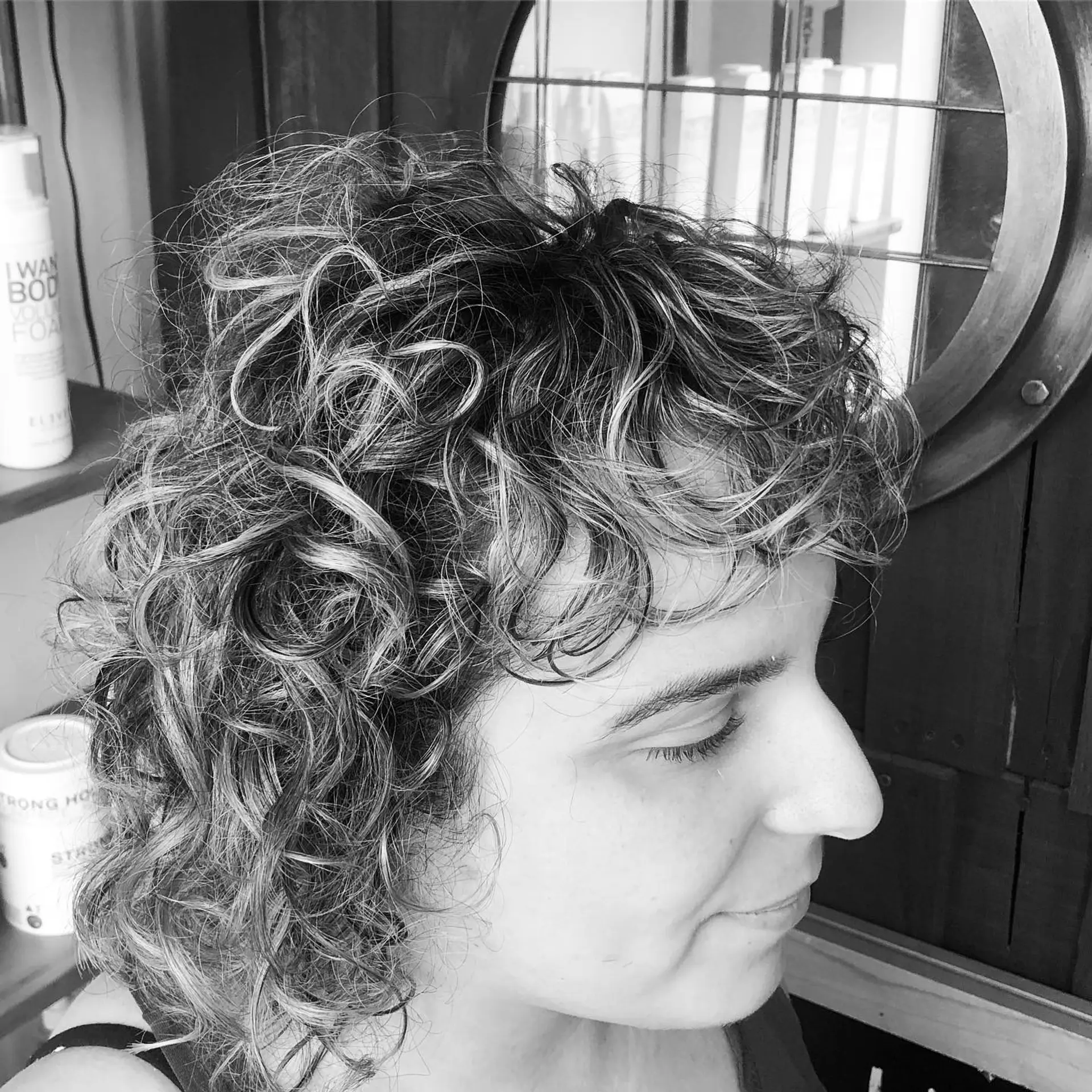 Short curly haircut with natural defined ringlets and brow-skimming curly bangs. 1