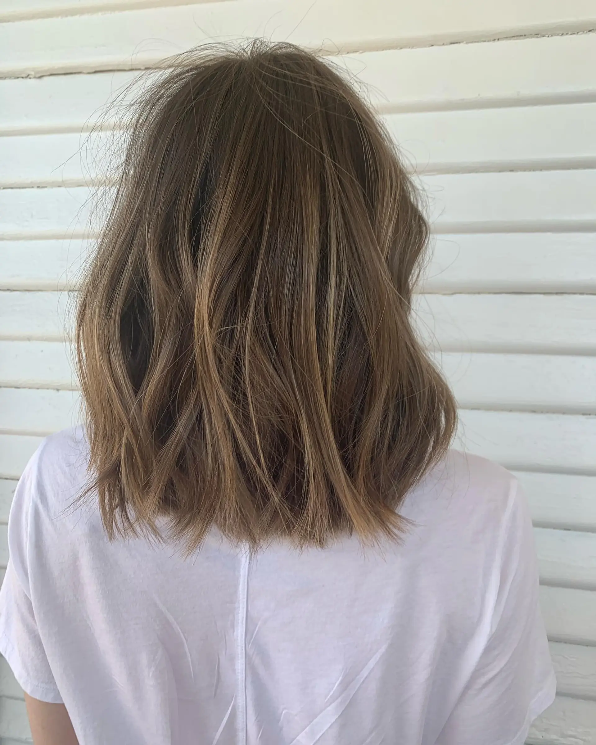 A medium-length textured blunt lob with subtle lived-in waves and fine dimensional highlights. 1