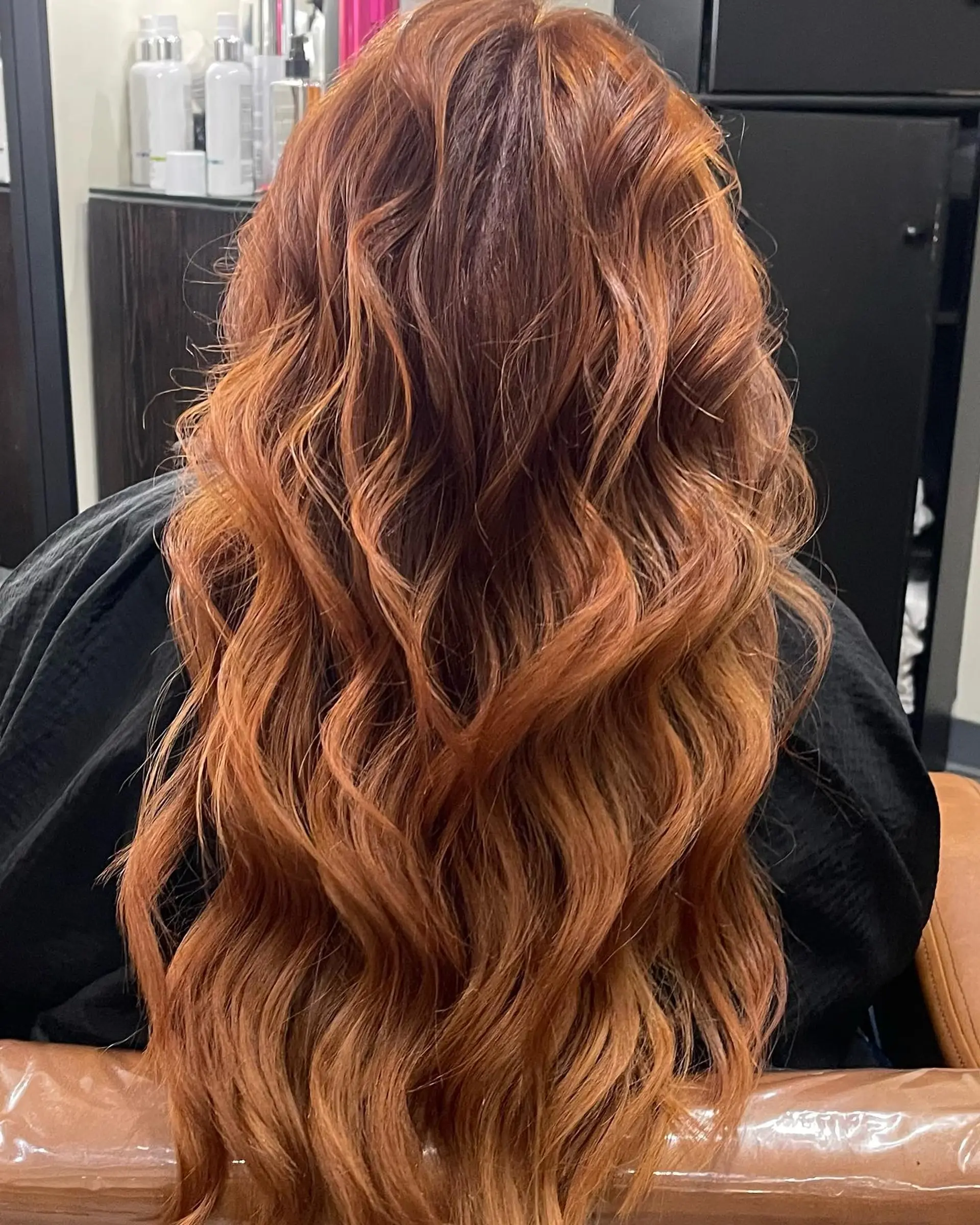 Long, dimensional copper red hair styled into flowing, loose textured waves. 1