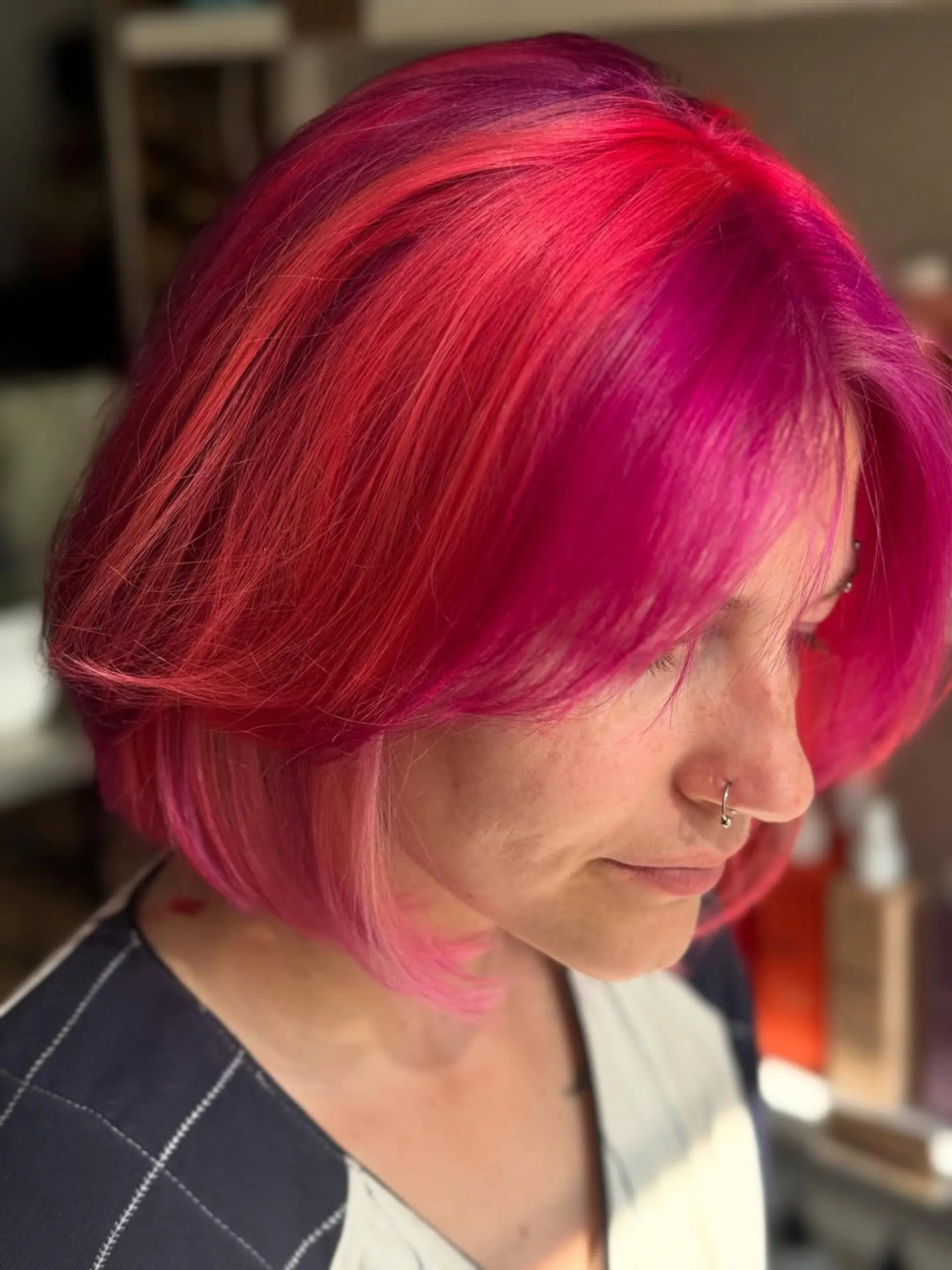 A sleek, short layered bob with a vibrant split-dye or multi-tonal color application featuring bold shades of fuchsia, hot pink, and magenta. 1