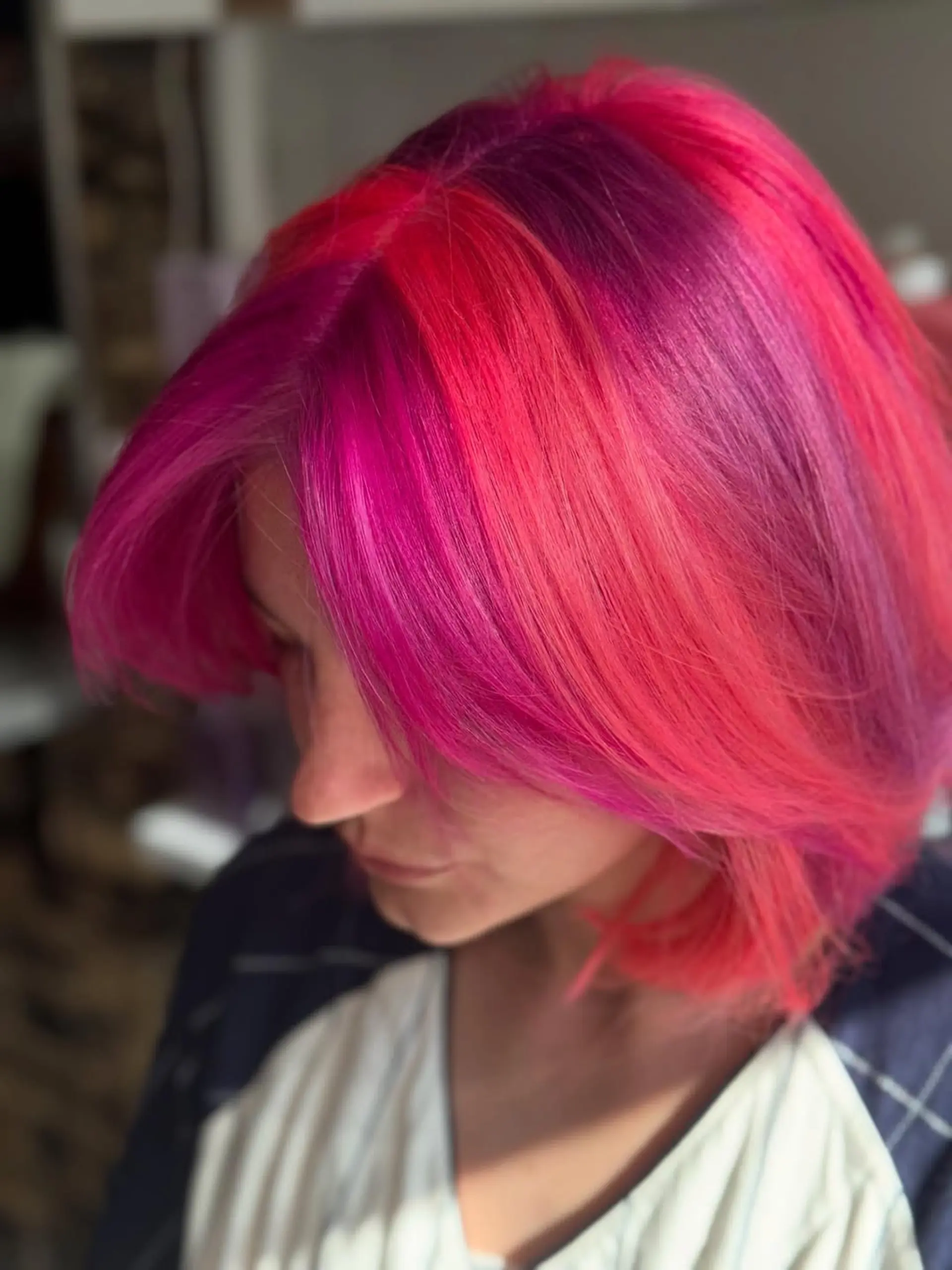 A sleek, short layered bob with a vibrant split-dye or multi-tonal color application featuring bold shades of fuchsia, hot pink, and magenta. 5