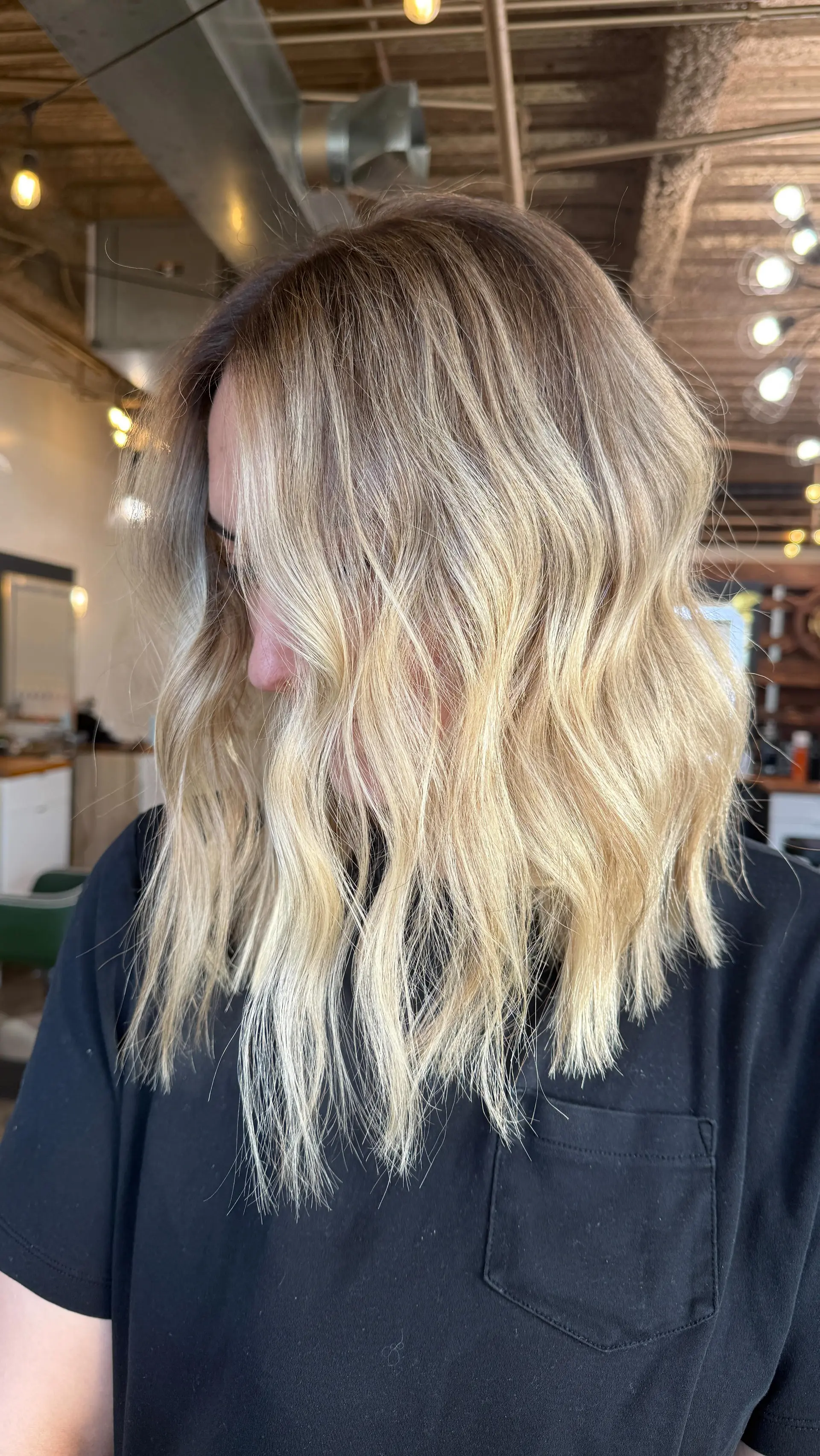 A textured blonde lob styled in relaxed waves with a seamless root smudge. 1