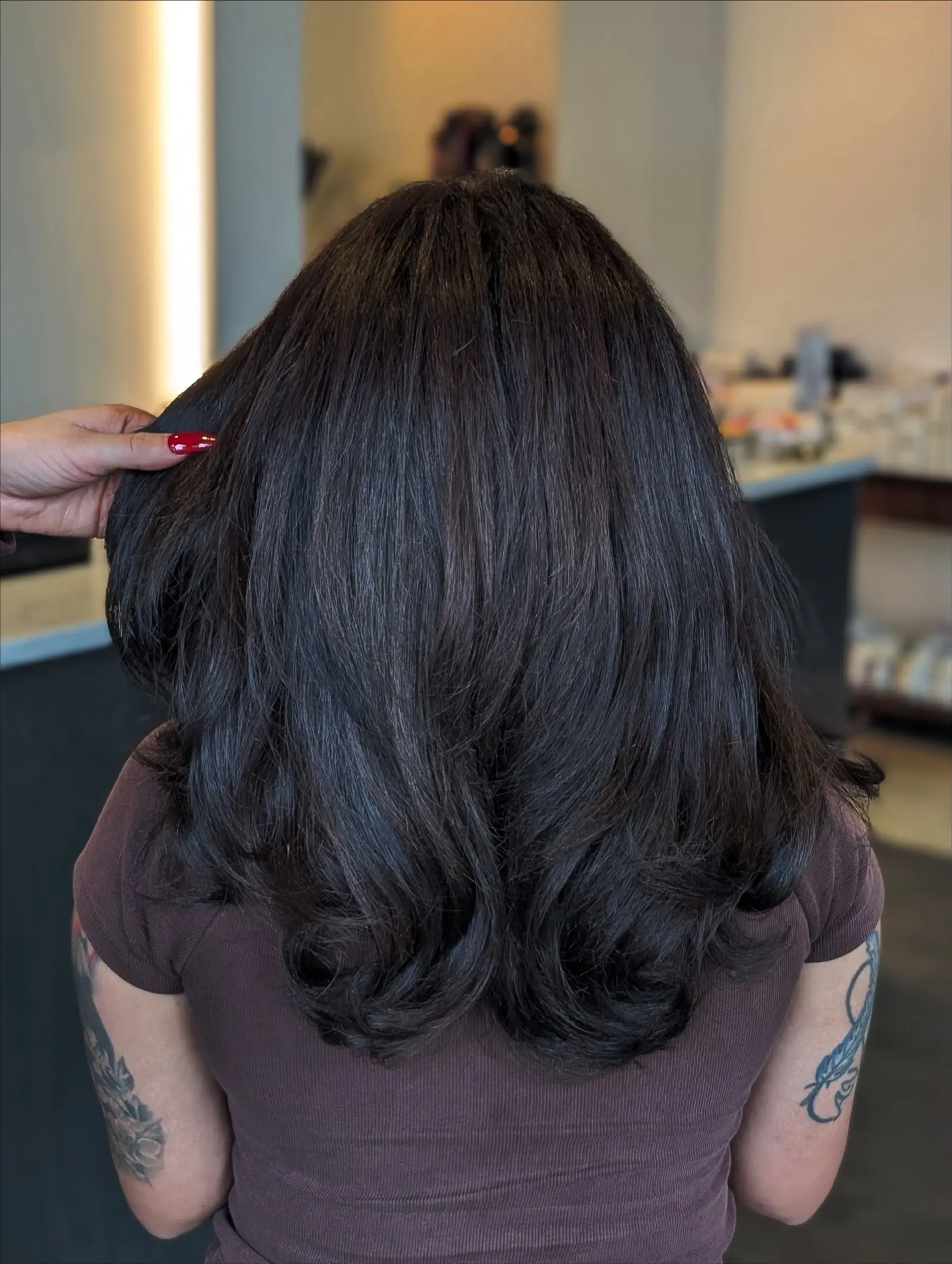 Rich dark espresso brunette hair with soft layers, styled into a smooth, voluminous blowout with flipped ends. 1