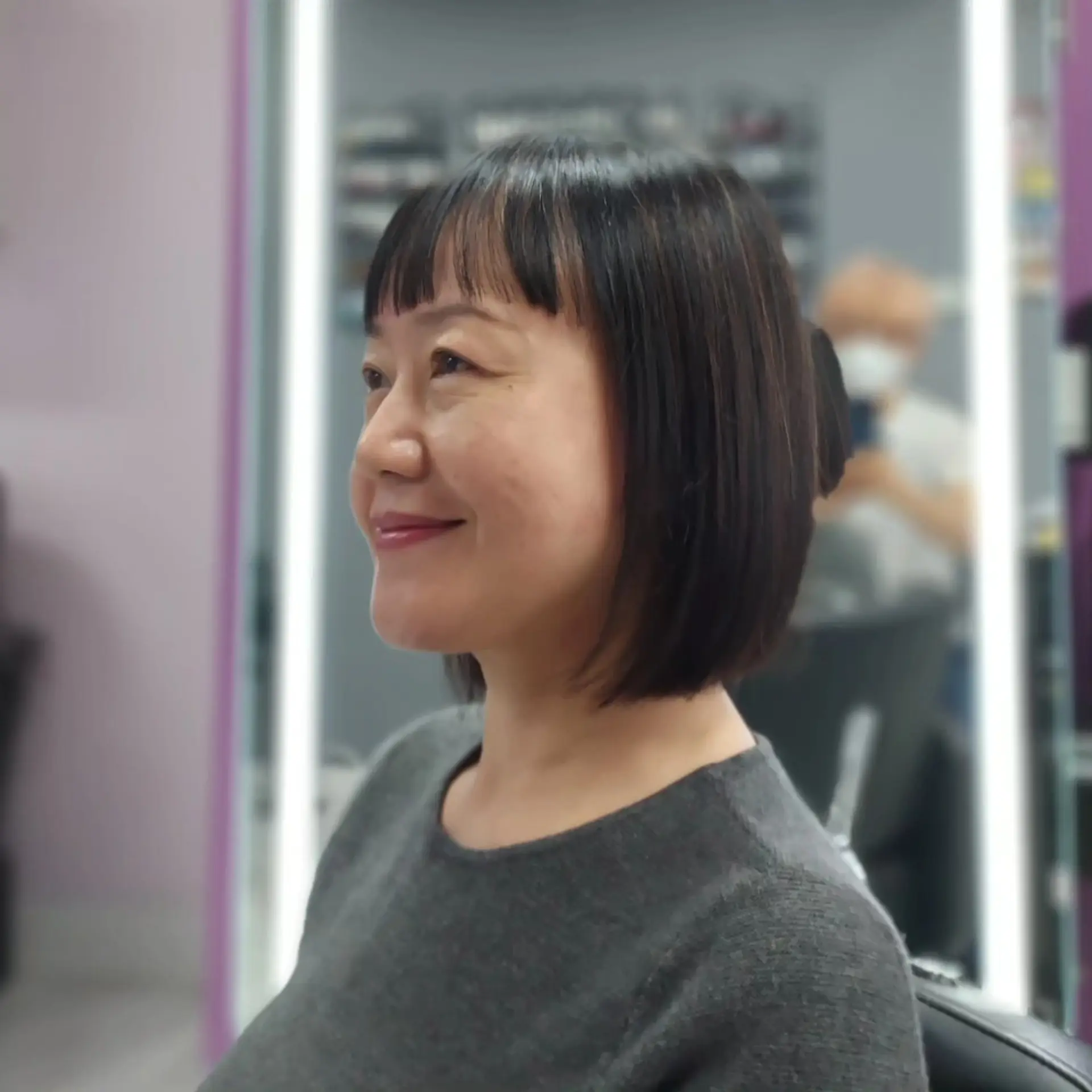 A sleek chin-length short bob featuring straight-across textured fringe bangs. 1