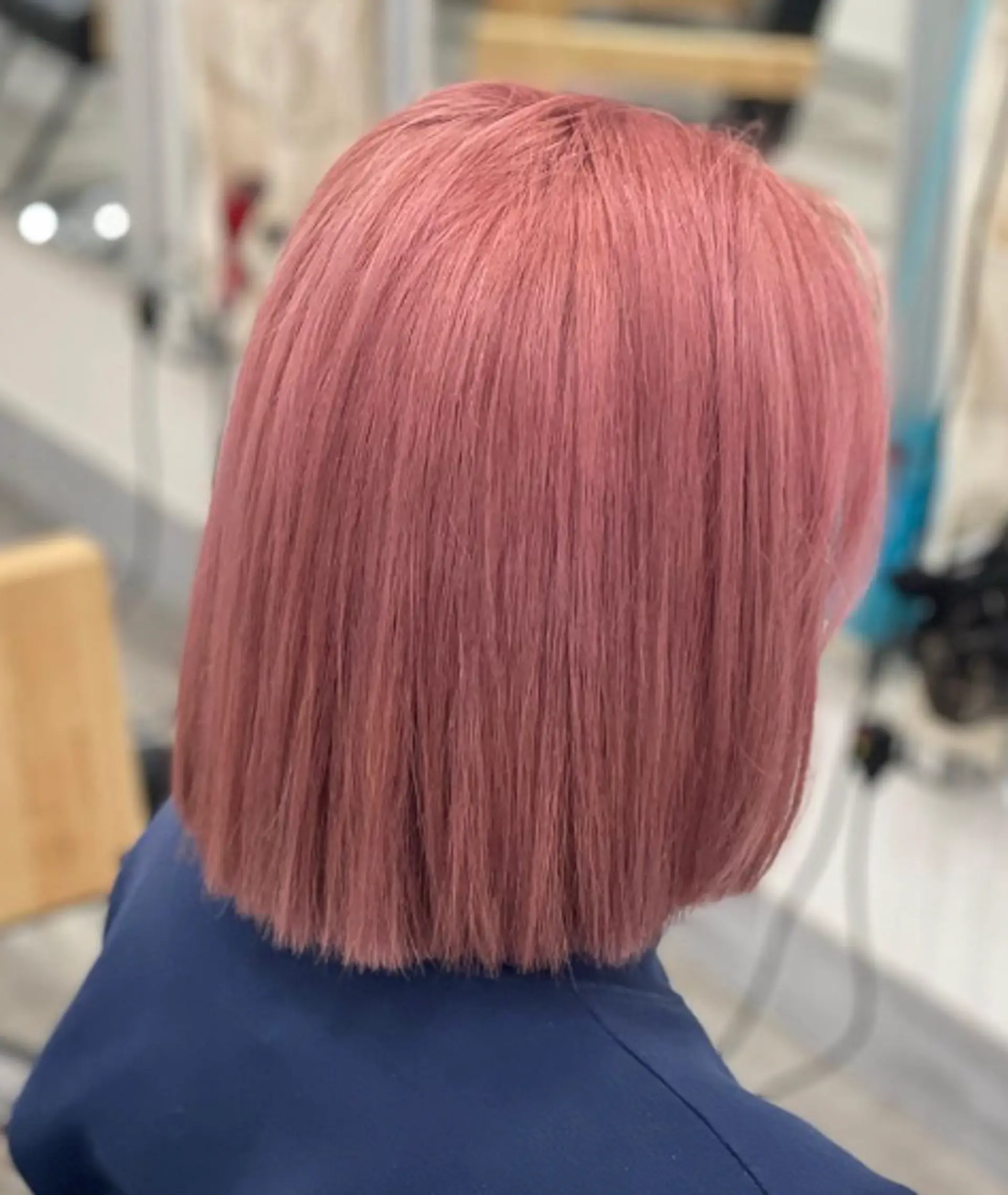 A sleek, straight medium-length bob dyed in a soft, pastel pink hue. 2