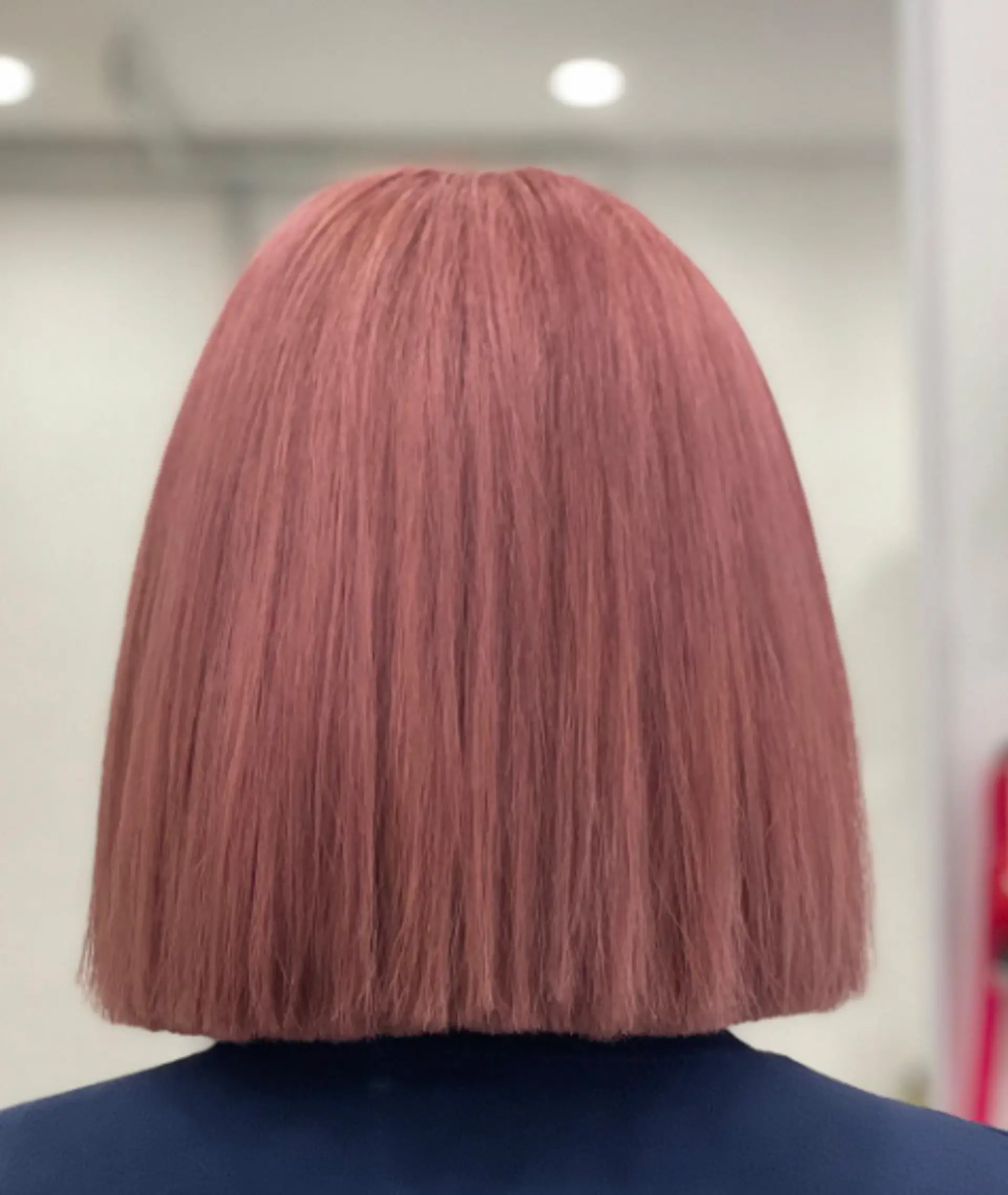 A sleek, straight medium-length bob dyed in a soft, pastel pink hue. 3