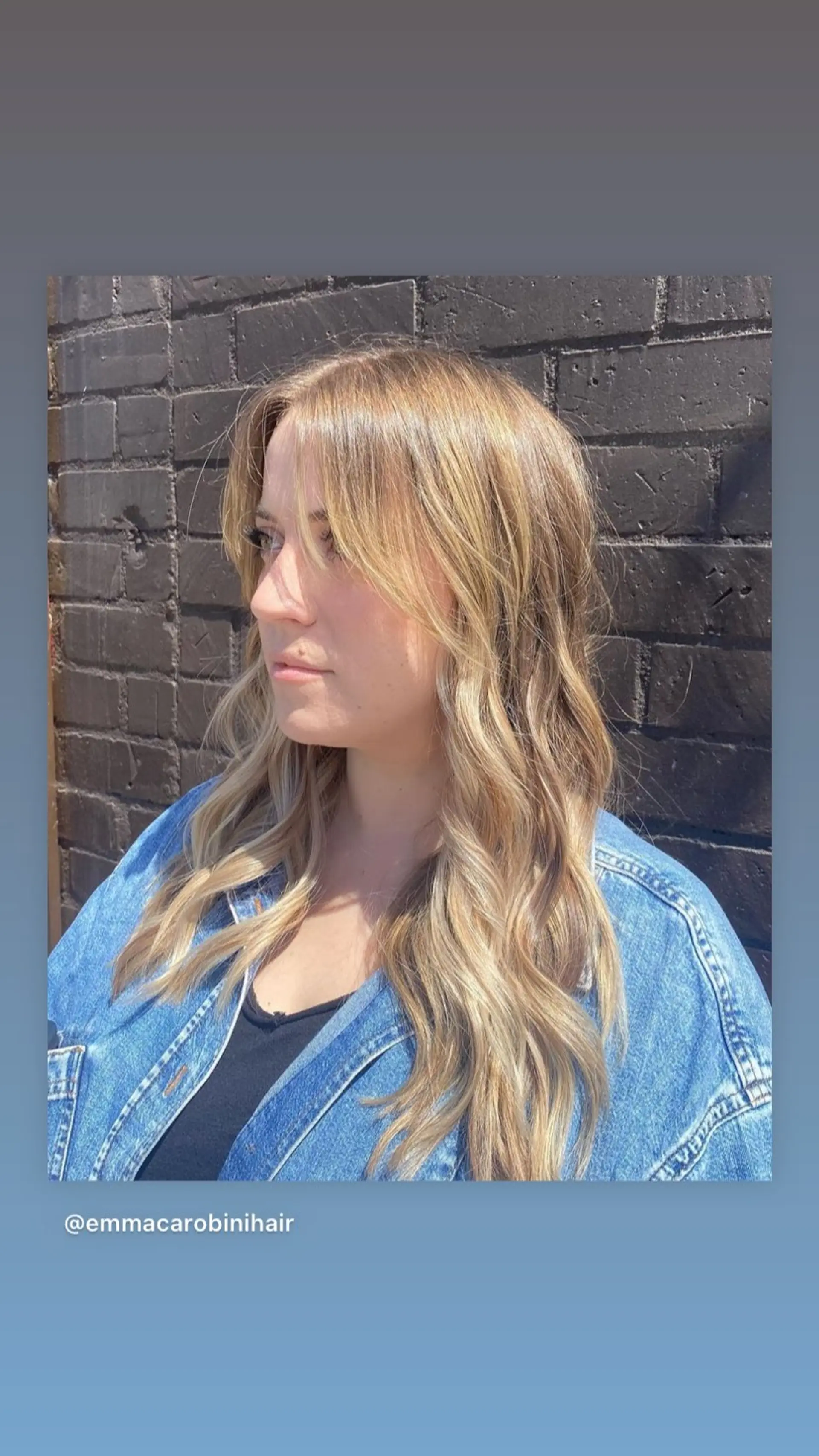 A medium-length wavy hairstyle with face-framing layers and soft curtain bangs, featuring a trendy bronde color. 1