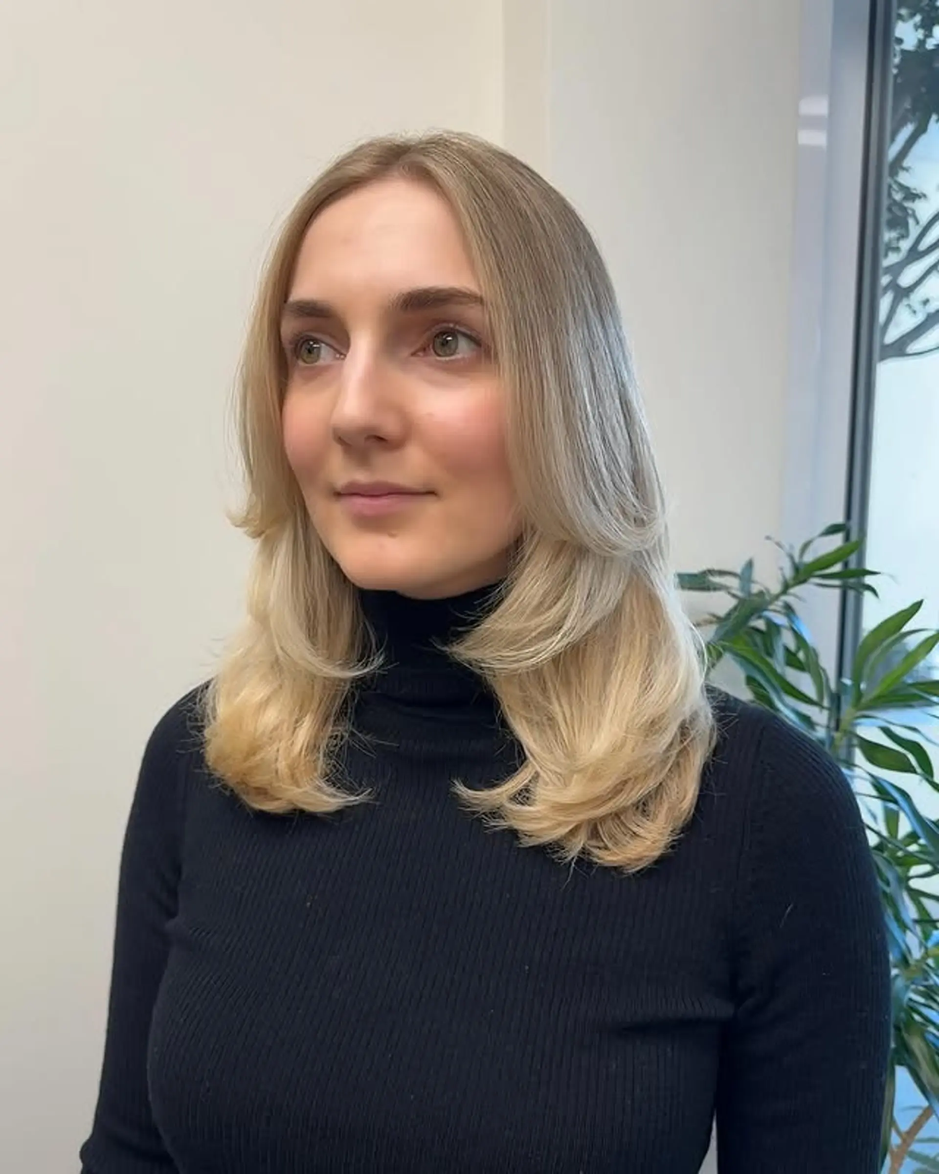 This hairstyle features face framing layers and subtle curtain bangs. 1