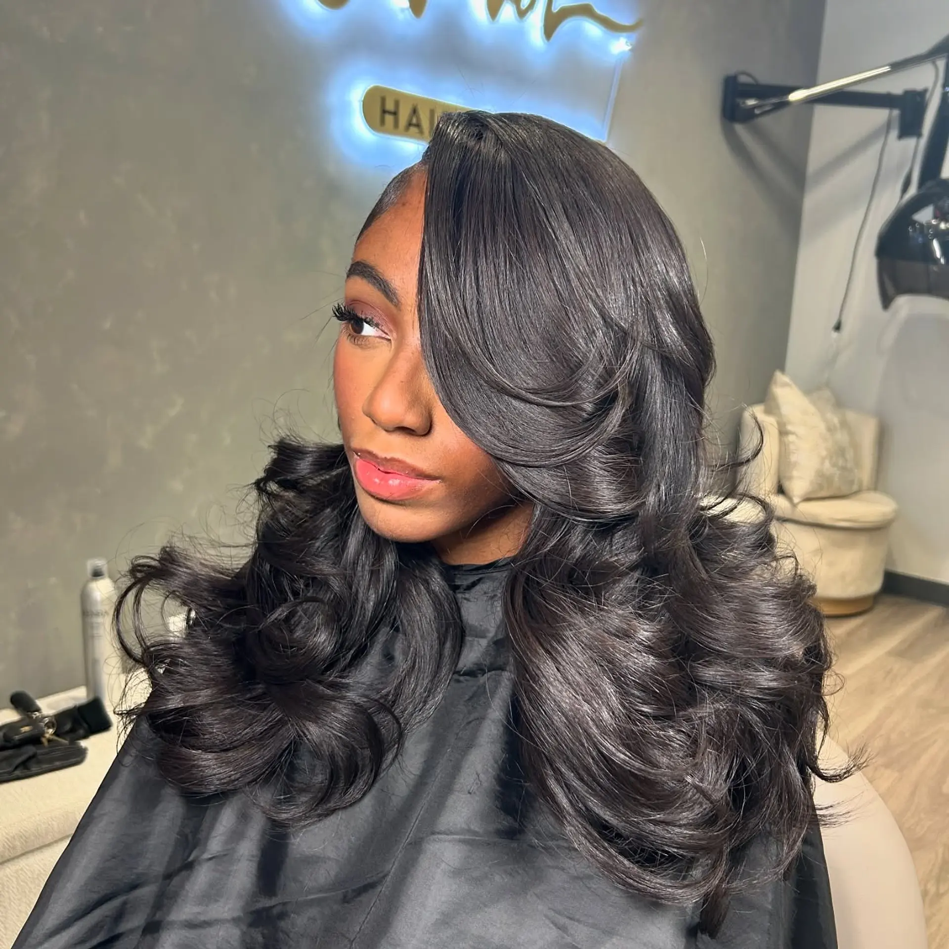 Long, wavy sew-in hairstyle with a glamorous layered cut and deep side part. 1