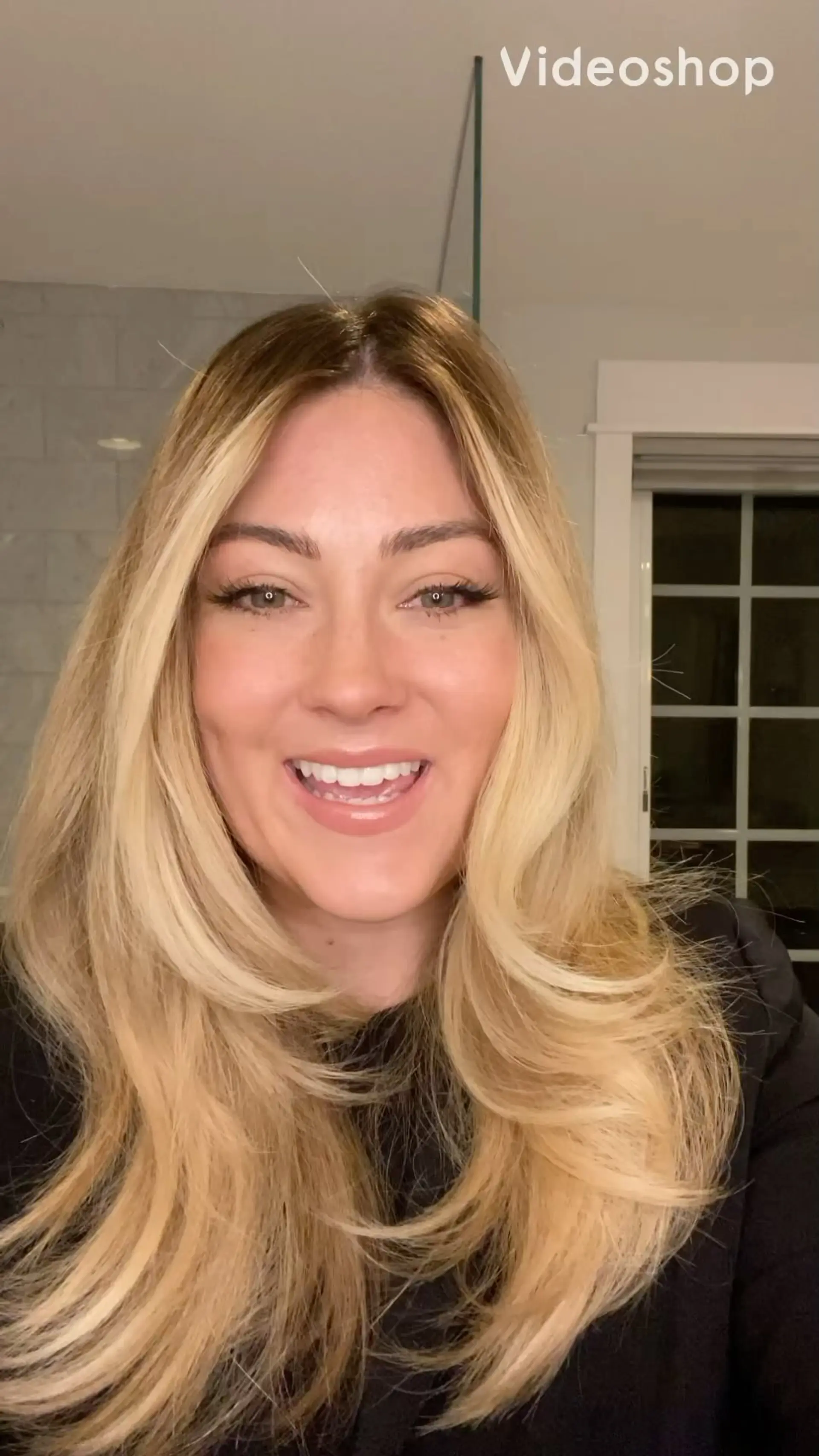 Long blonde hair styled into a voluminous, bouncy blowout with face-framing layers and soft, outward-curling ends. 1