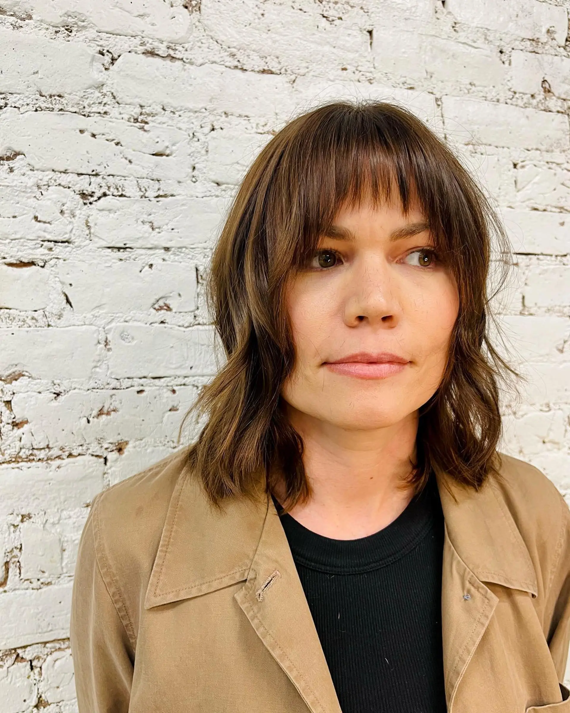 Shoulder-length textured bob with loose, piecey waves and wispy front fringe. 1