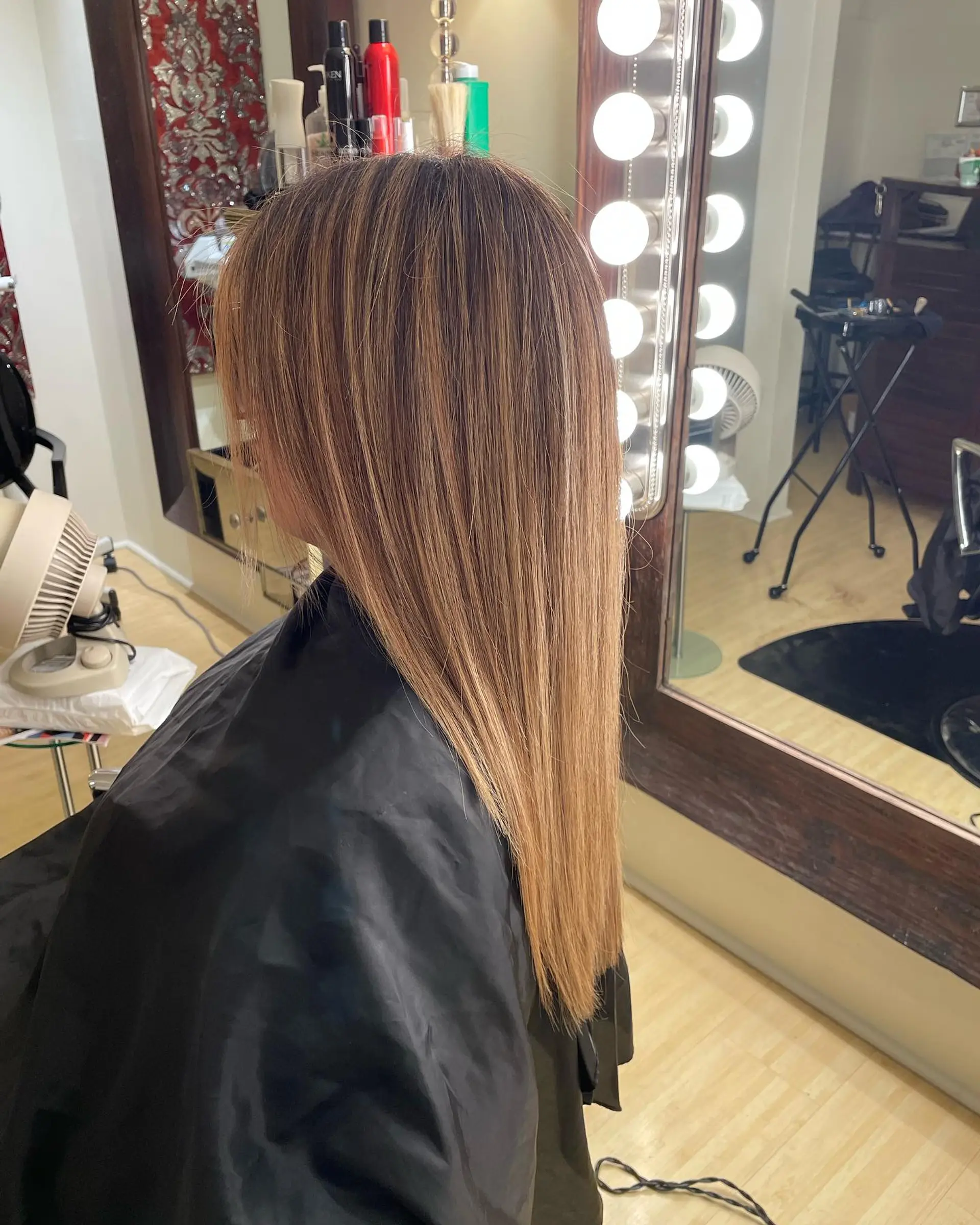 Long, sleek straight hair featuring fine honey blonde highlights throughout a warm light brown base. 1