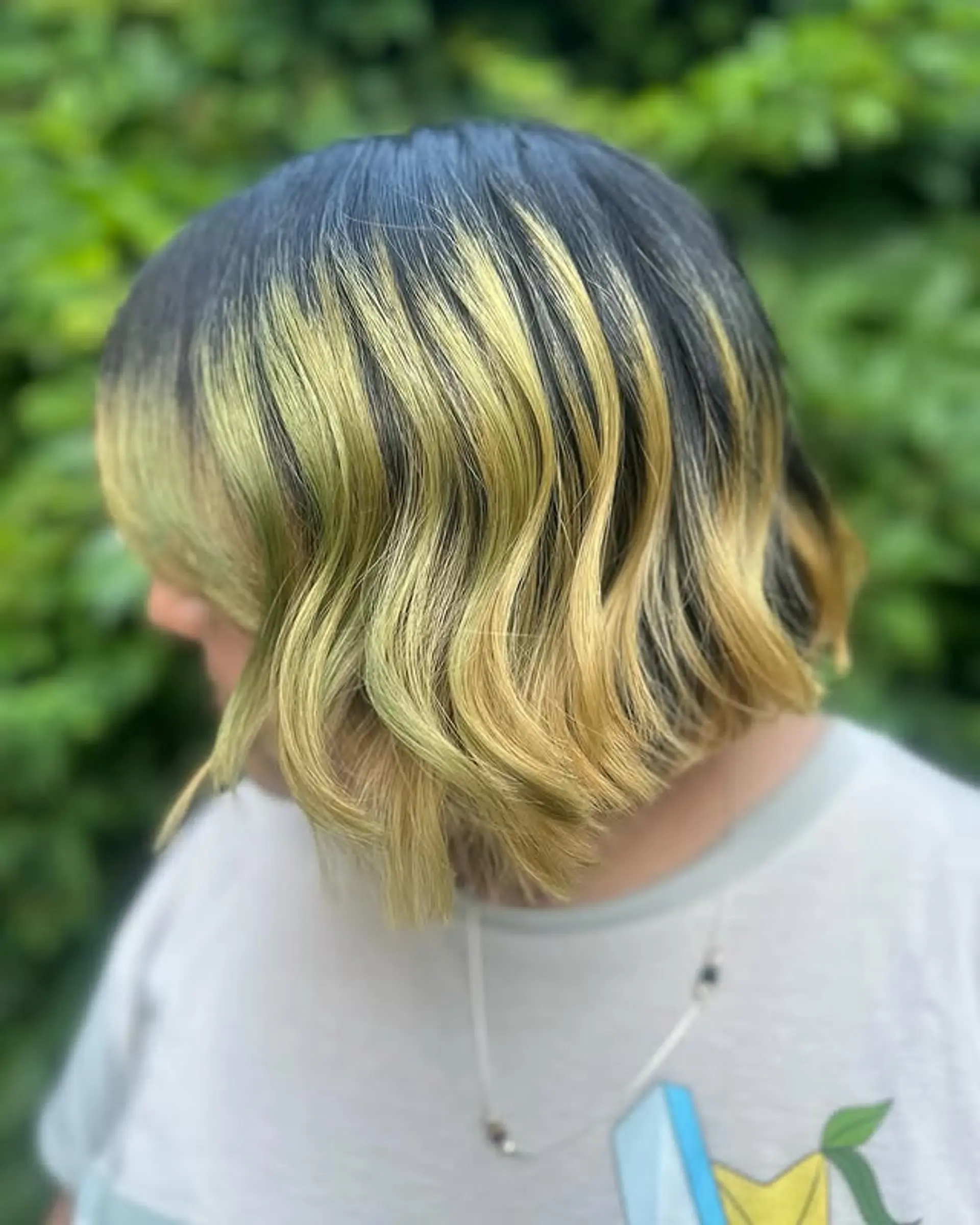 A wavy bob with a shadow root effect, blending dark roots into honey blonde waves. 1