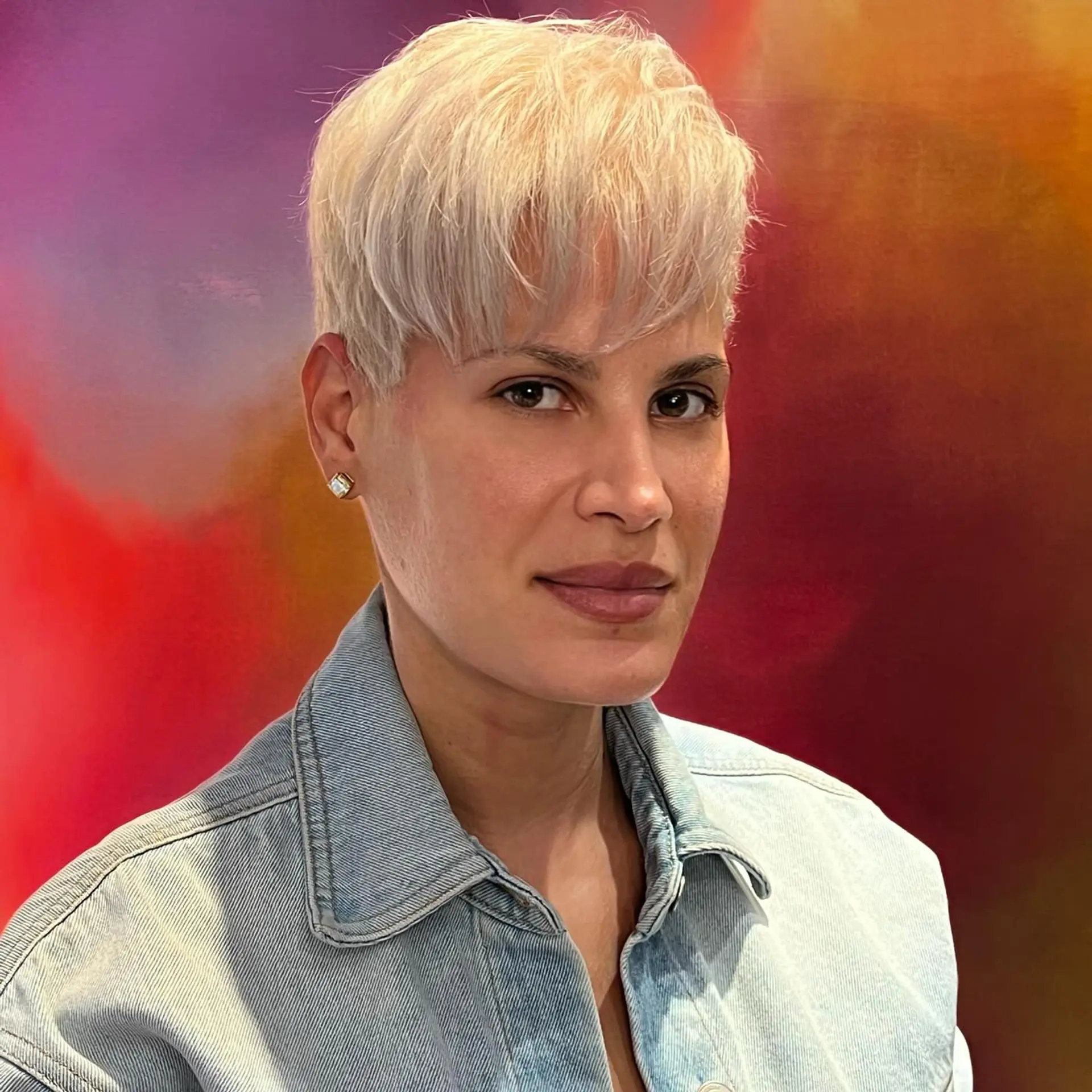 A cool-toned platinum blonde pixie cut with soft, textured forward-falling fringe. 1