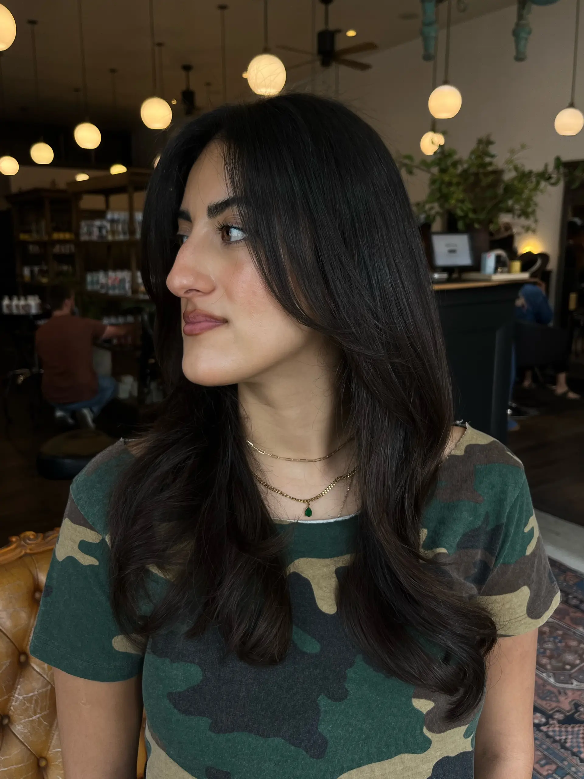 Long dark brown hair cut with soft face-framing layers and styled into a voluminous, bouncy blowout. 1