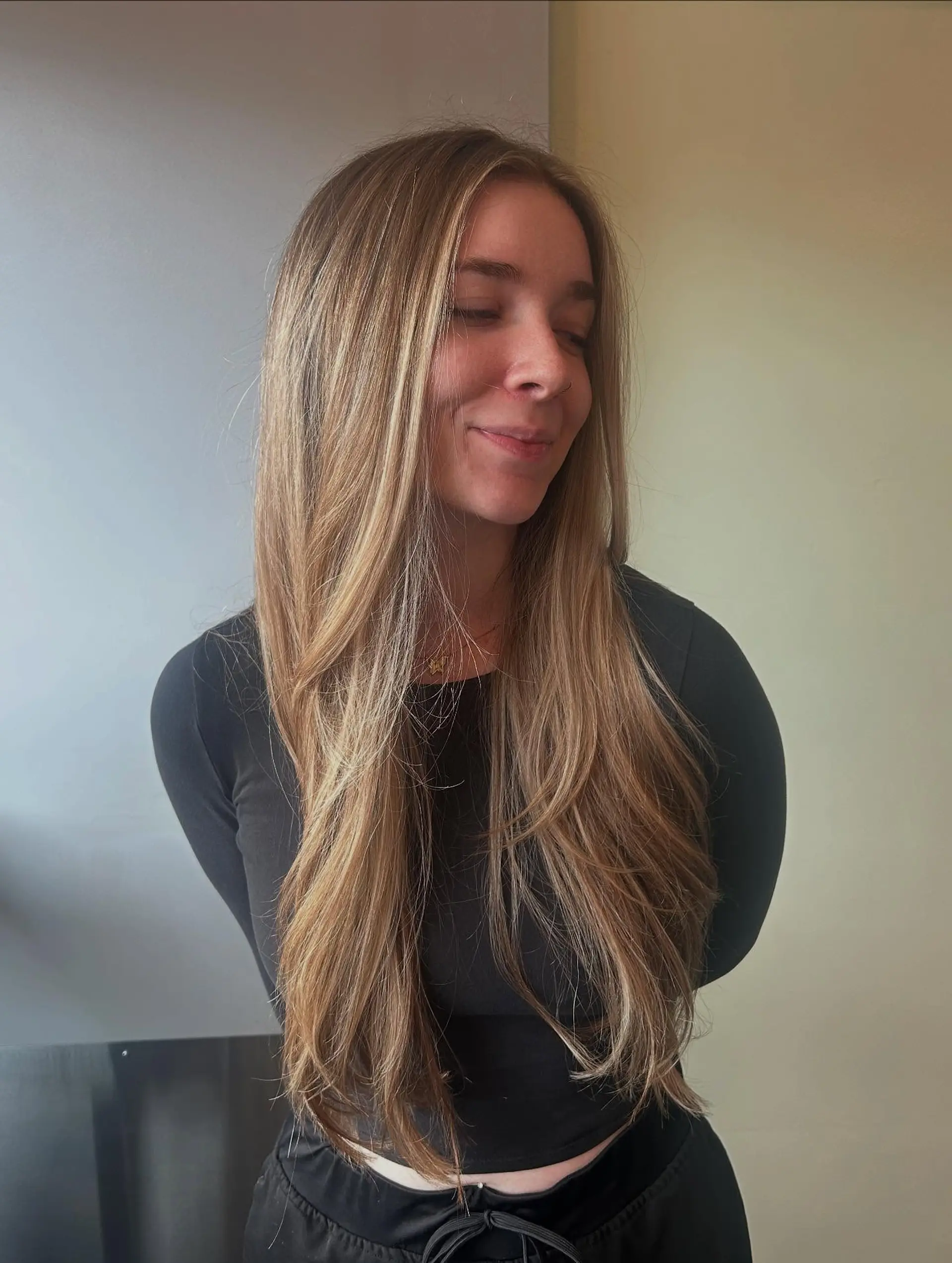 Long layered warm blonde hair featuring dimensional balayage highlights styled in a sleek, smooth blowout. 1