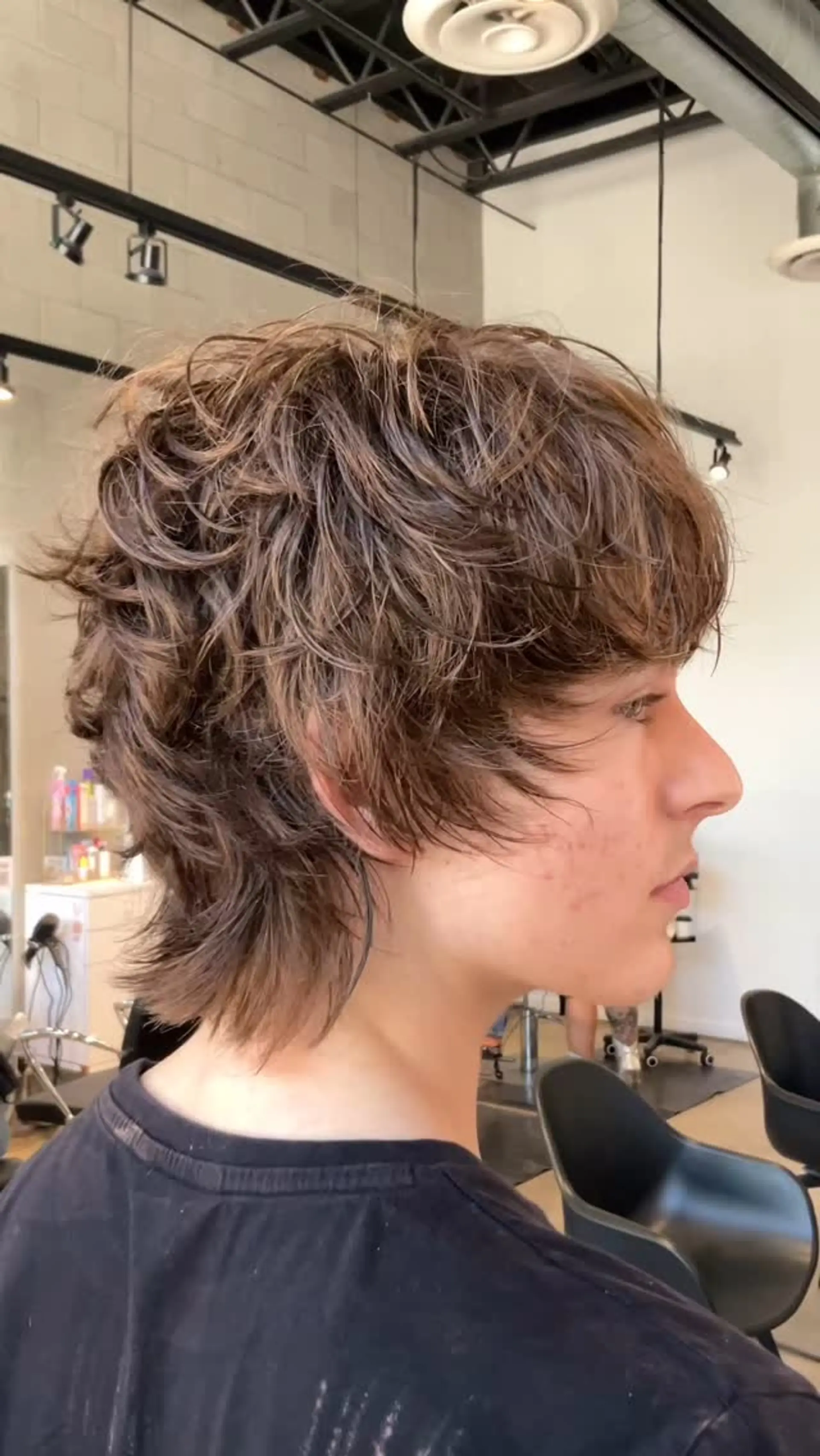 A razor-cut textured shag featuring choppy, tousled layers, a forward-swept fringe, and length extending past the nape. 1