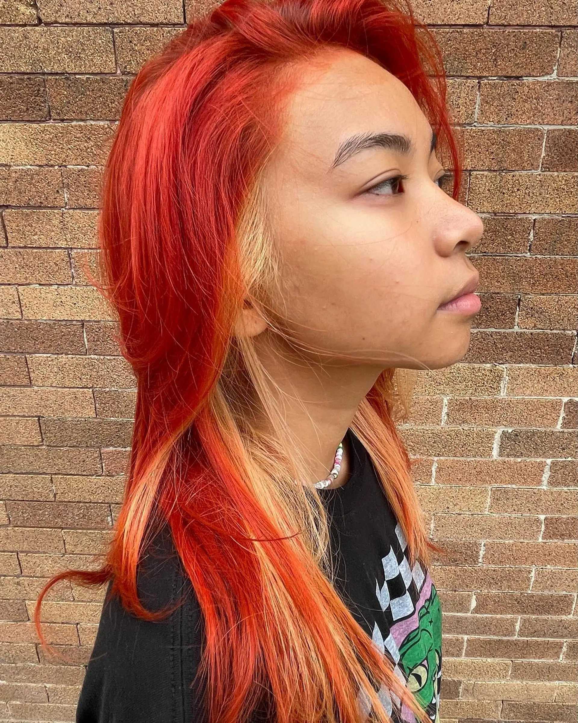 Long straight hair with a bold money piece highlight style, featuring red and copper tones. 1