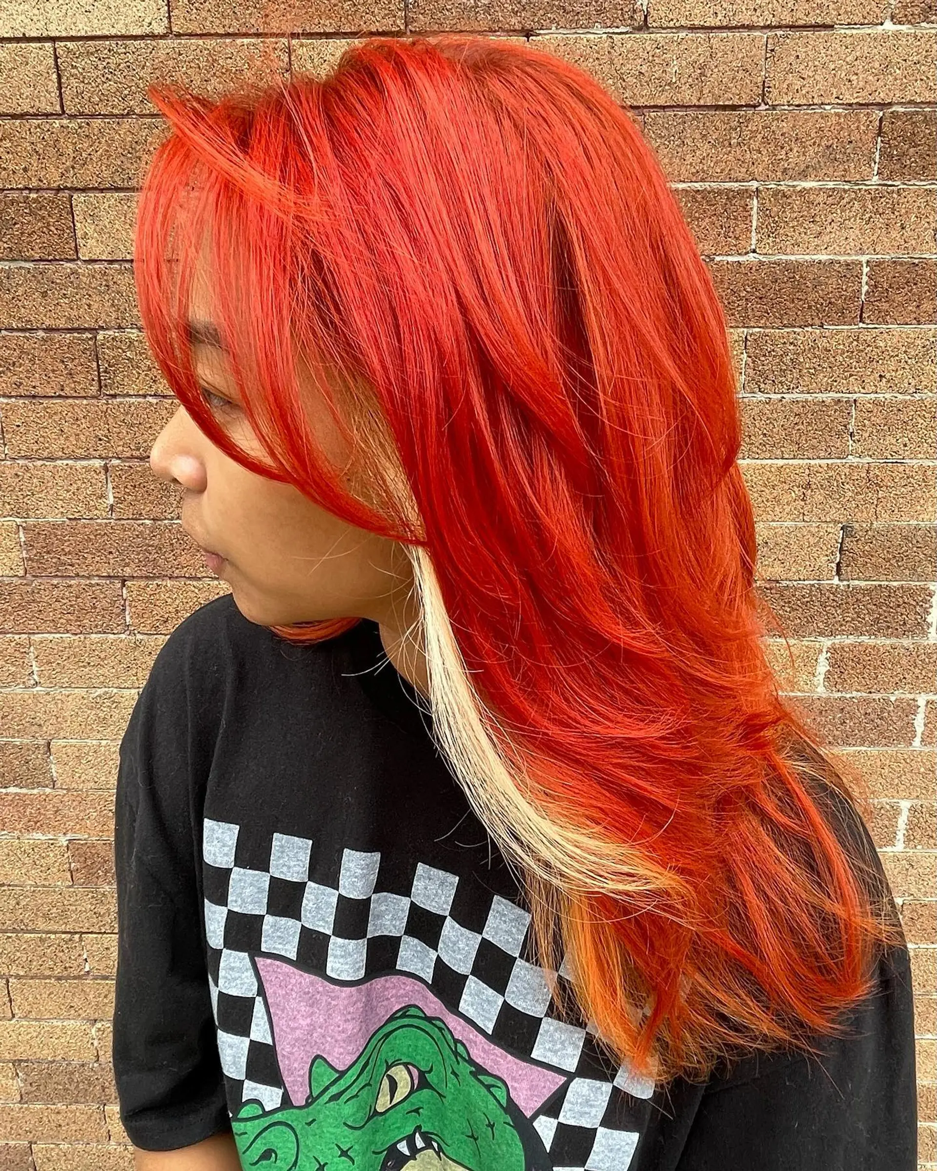 Long straight hair with a bold money piece highlight style, featuring red and copper tones. 2