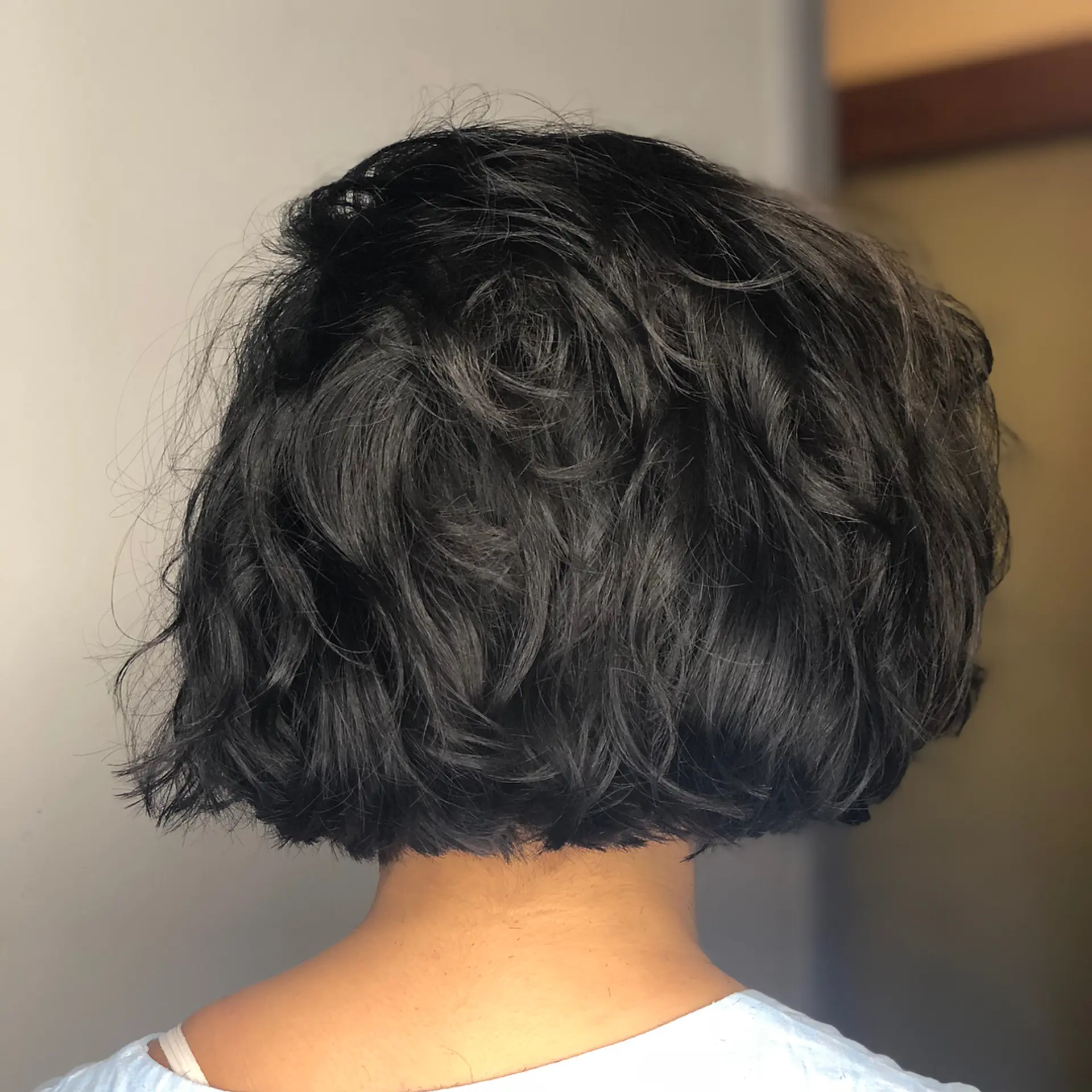 A textured chin-length bob cut with soft, tousled waves that provide natural body and movement. 1