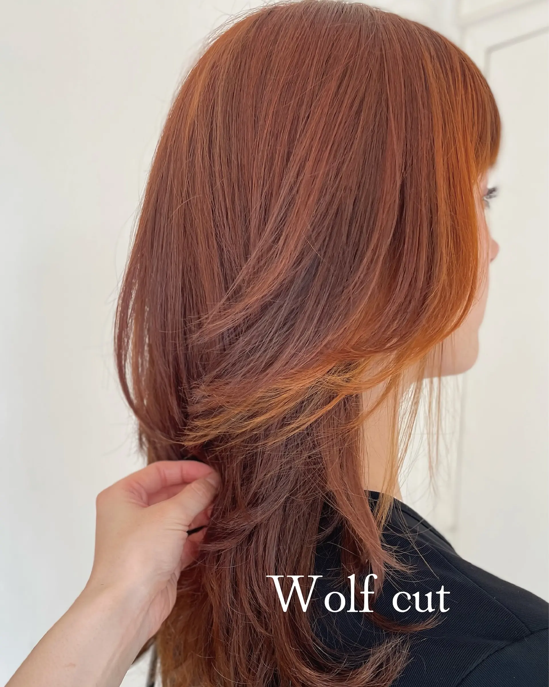 A modern wolf cut in rich copper tones featuring heavily textured, face-framing feathered layers. 1