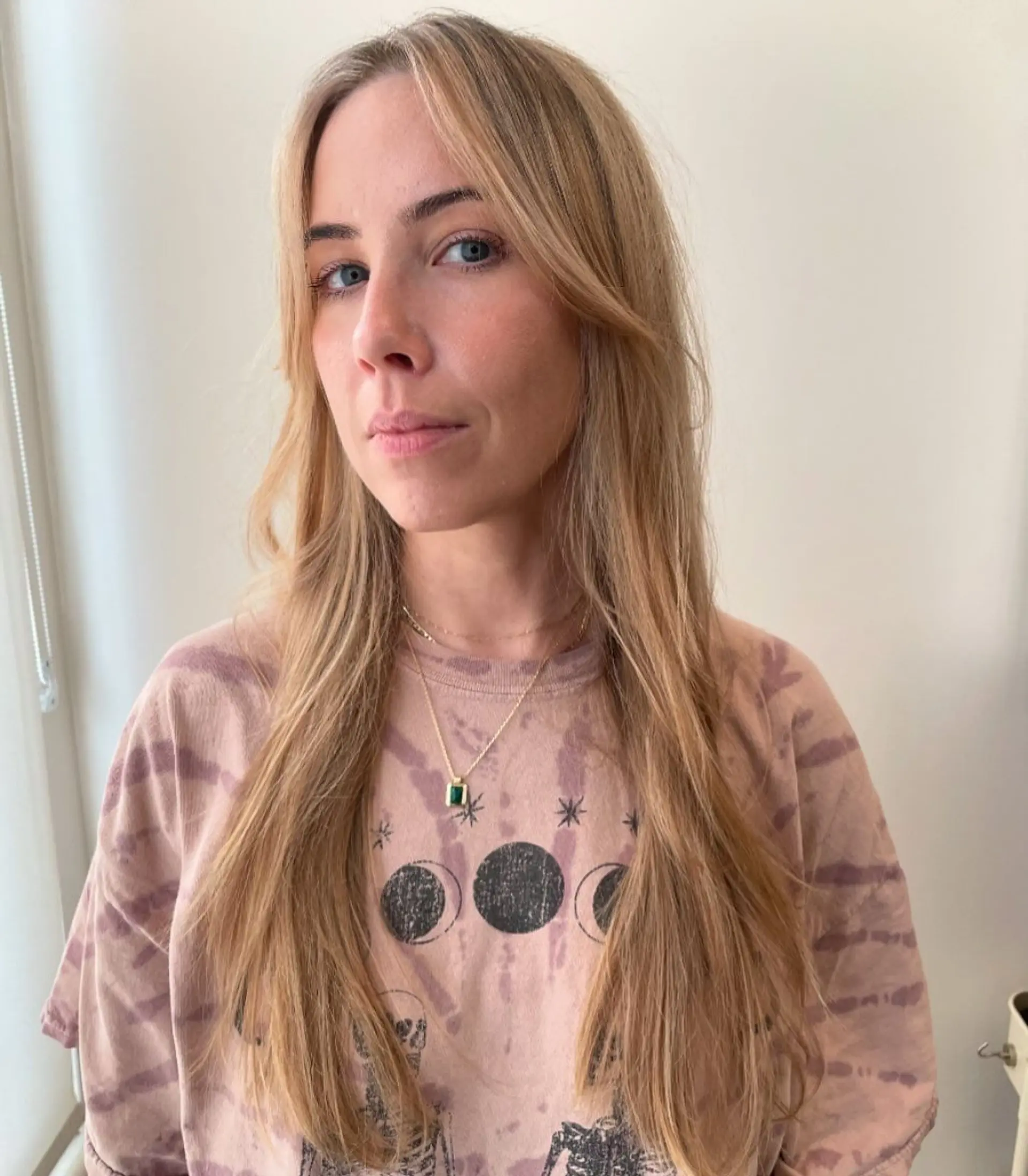 A very long, wavy blonde hairstyle with face-framing layers and sun-kissed highlights, featuring a natural, soft flow and subtle waves. 1