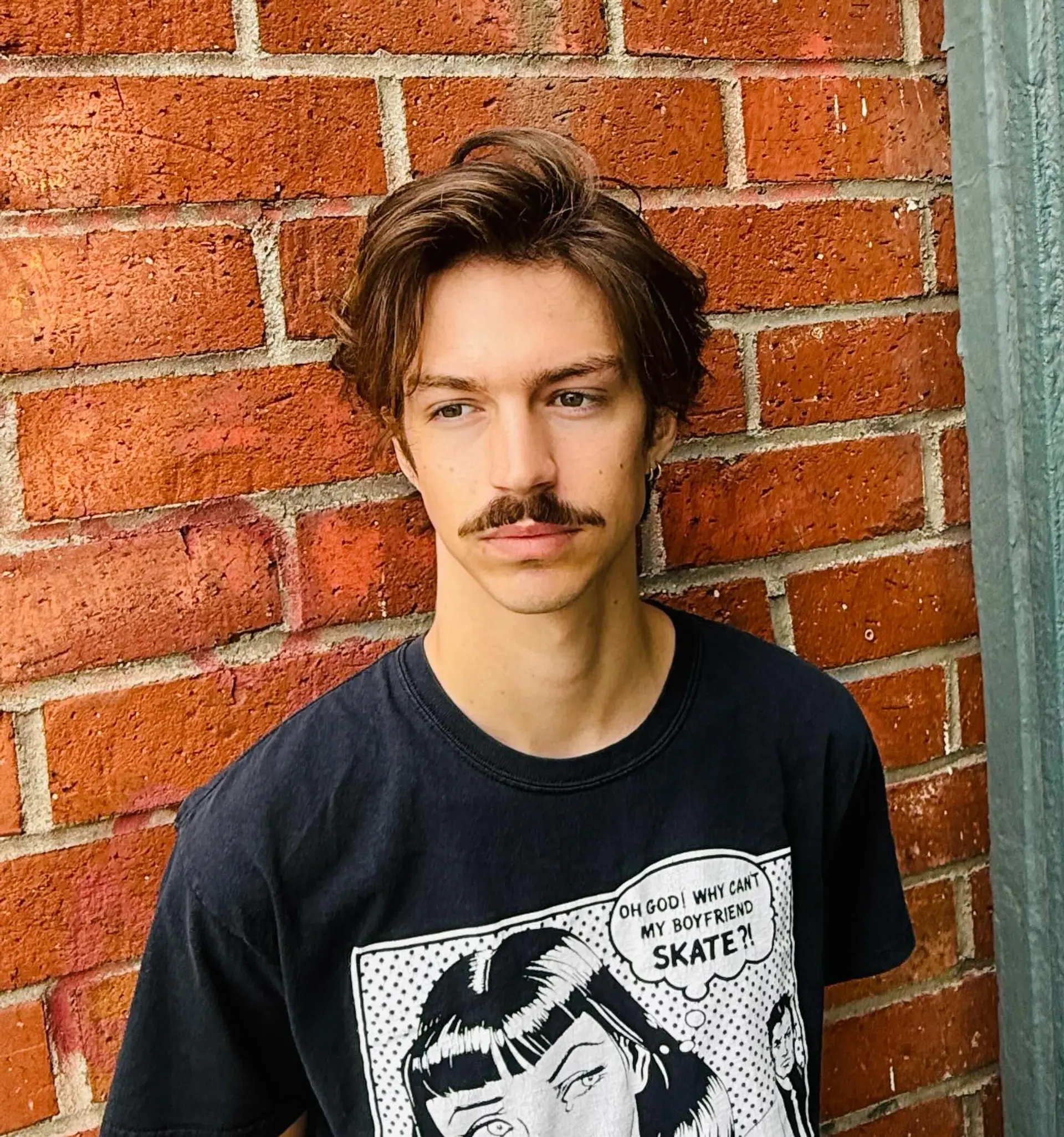 A medium-short textured men's haircut with soft layers and an off-center sweep creating natural movement. 1
