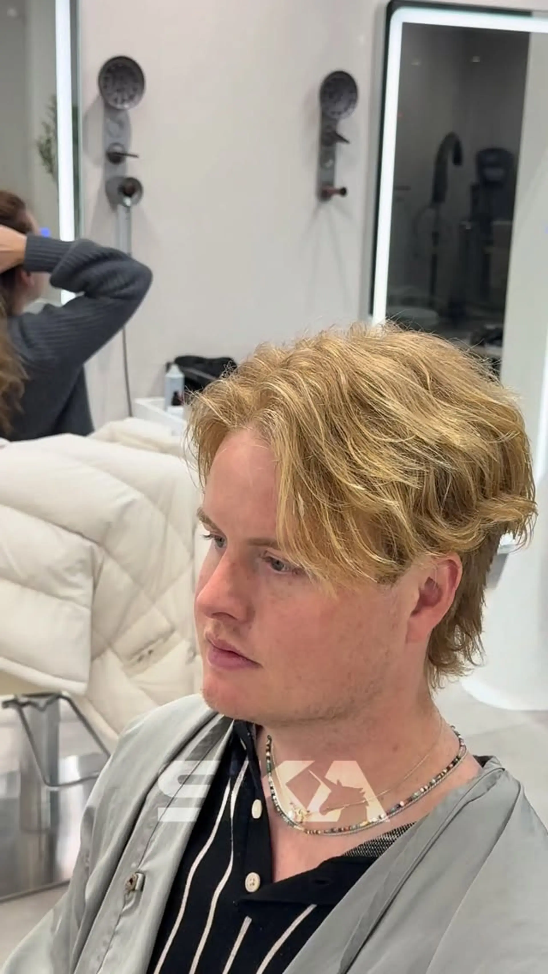 Medium-short textured haircut featuring soft waves, natural body, and center-parted curtain bangs. 1