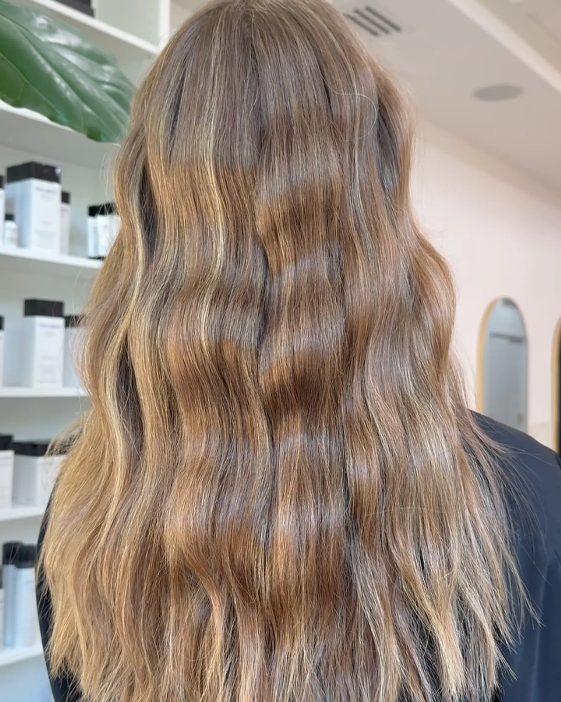 Long, flowing light brown hair styled in gentle textured waves with natural golden blonde highlights throughout. 1