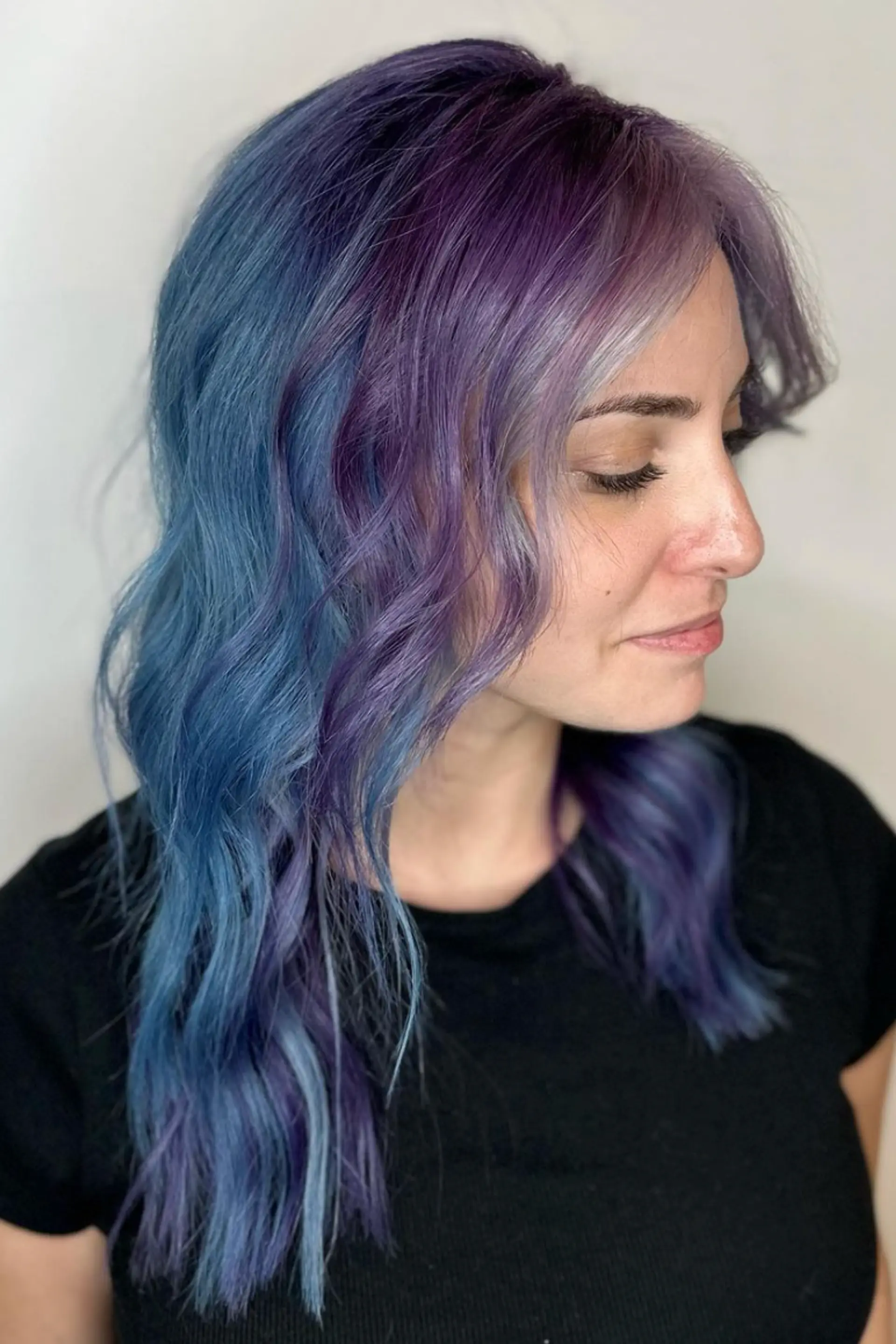 Medium-length wavy hair in lavender, purple, and blue tones with a center part and subtle waves.

Color by @simabeautynyc
 3