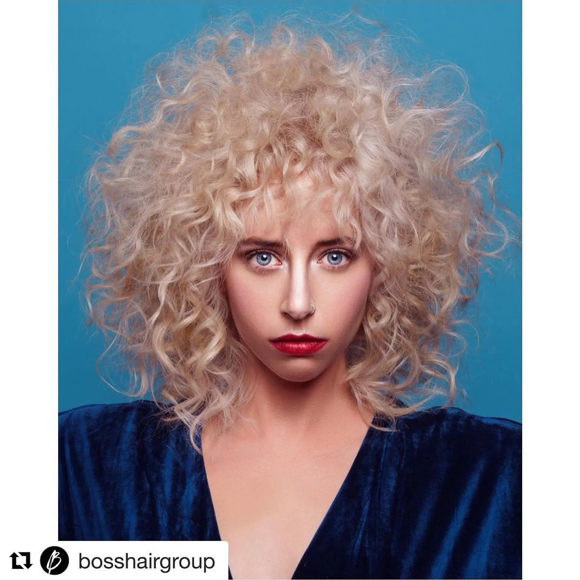 A voluminous, shoulder-length curly shag with full feathered bangs, styled with airy texture and maximum body. 1