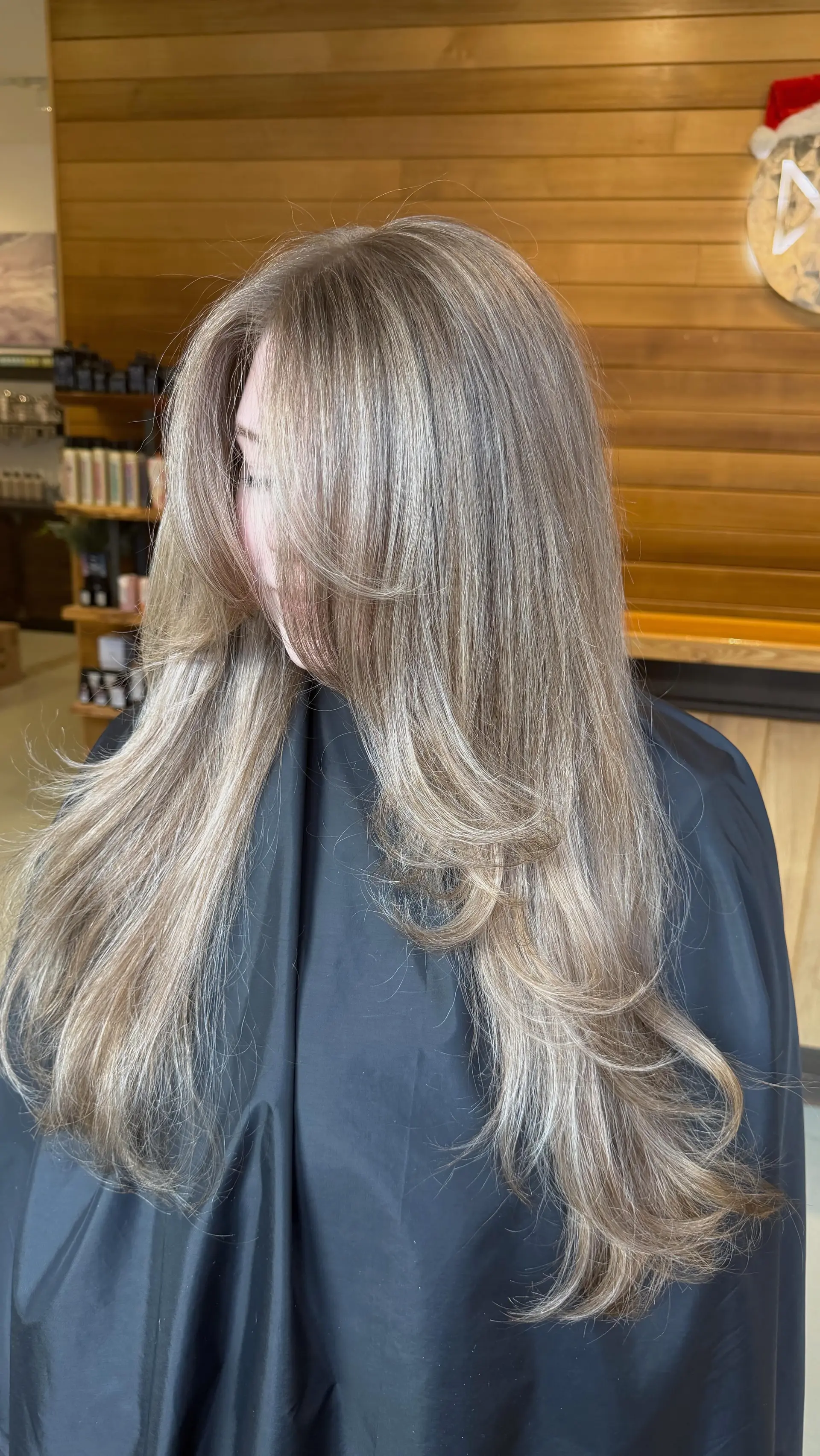 Long ash blonde hair cut in flowing layers with soft face-framing curtain bangs and a smooth blowout finish. 1