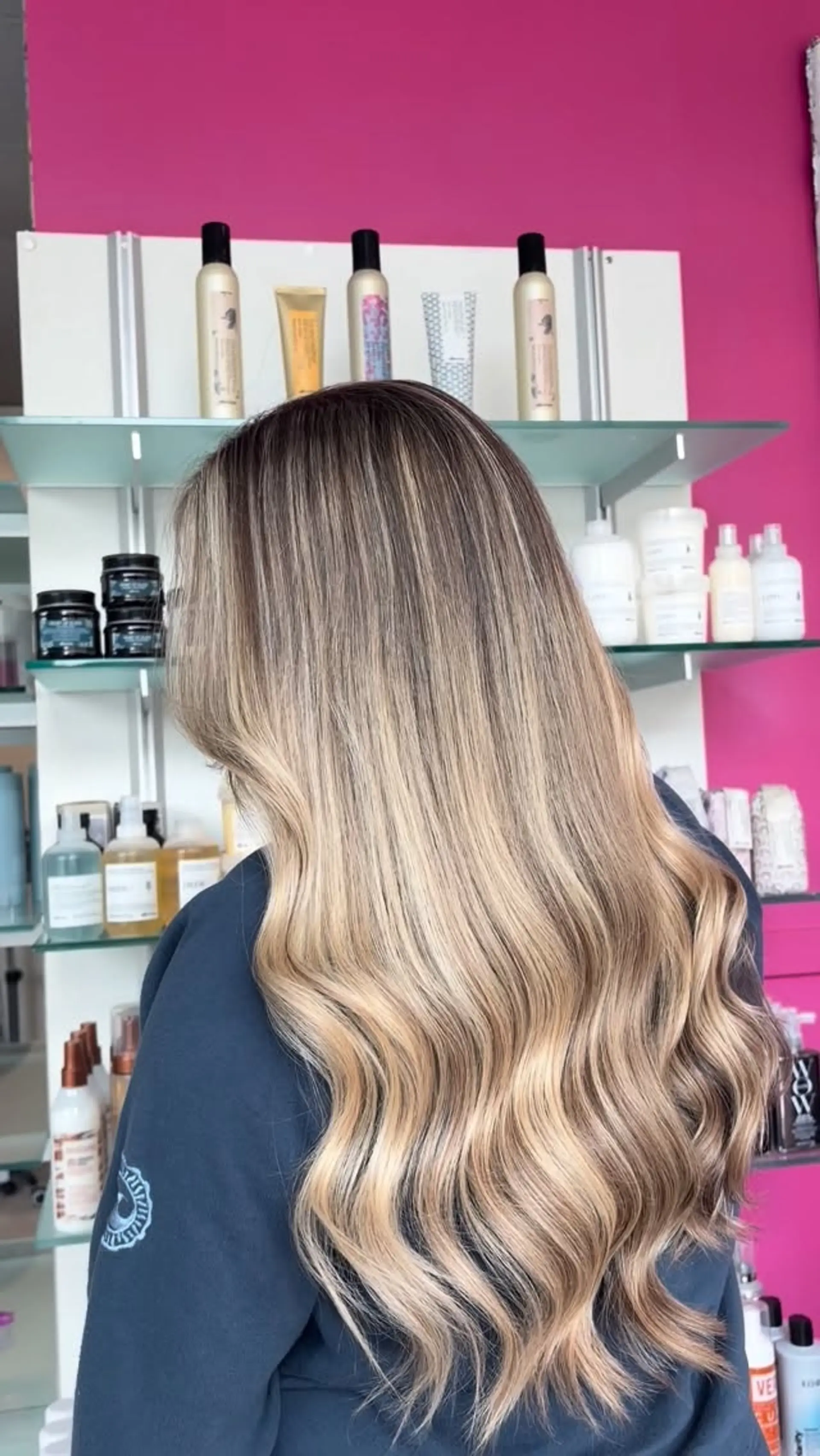 Long multi-tonal blonde hair featuring blended balayage highlights styled with soft, flowing waves. 1
