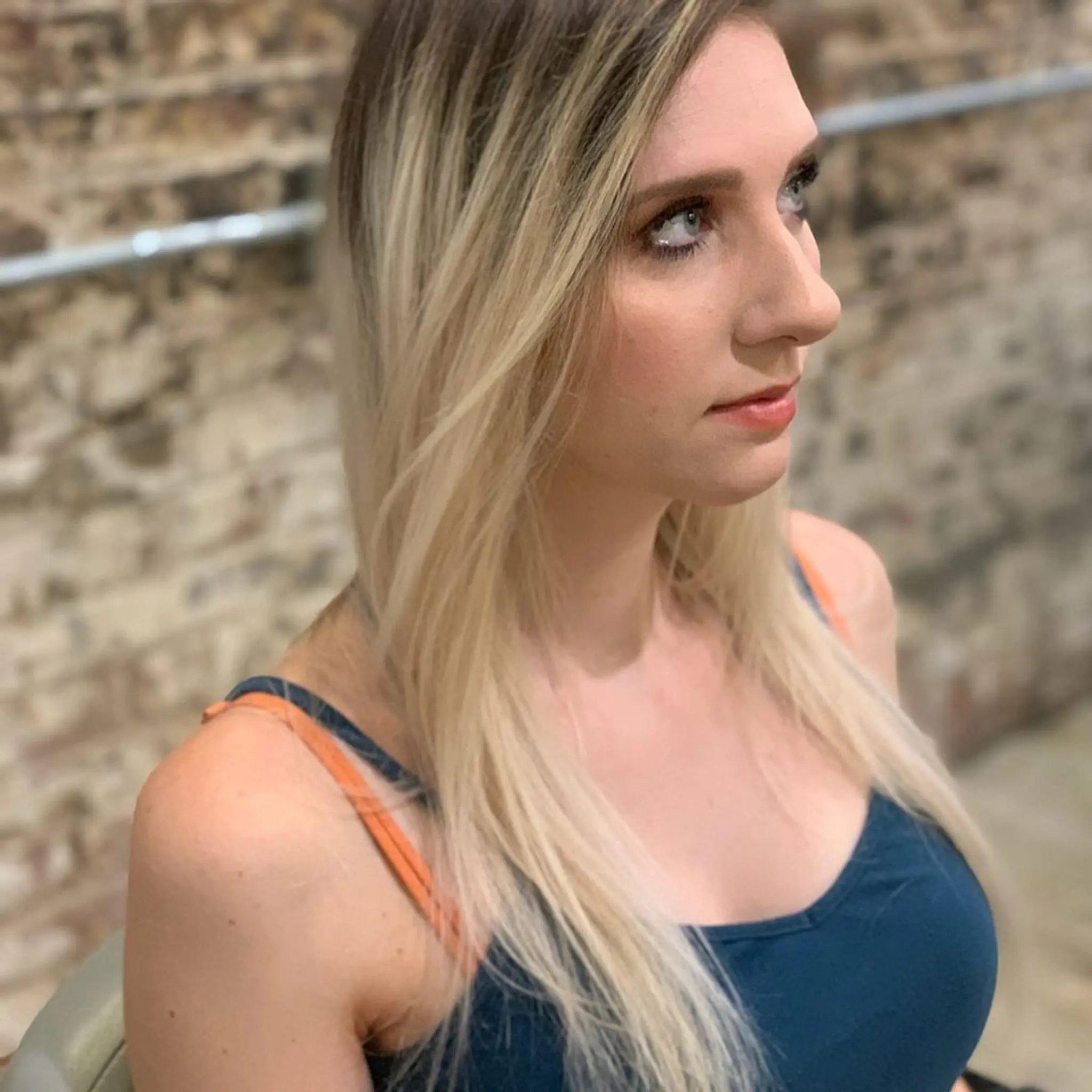 Long, rose gold wavy hair with a side part and soft layers, featuring pastel pink undertones and a trendy, voluminous look. 2