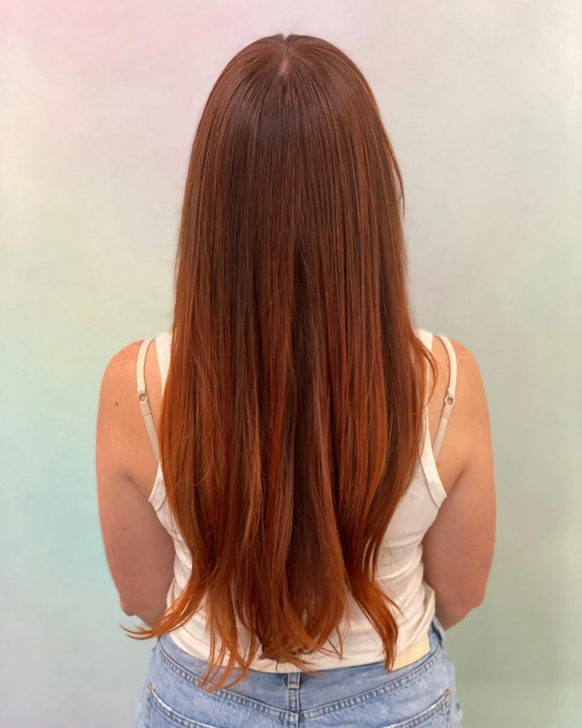 Long straight hair featuring a dimensional blend of dark brunette roots seamlessly fading into vibrant copper tones. 1