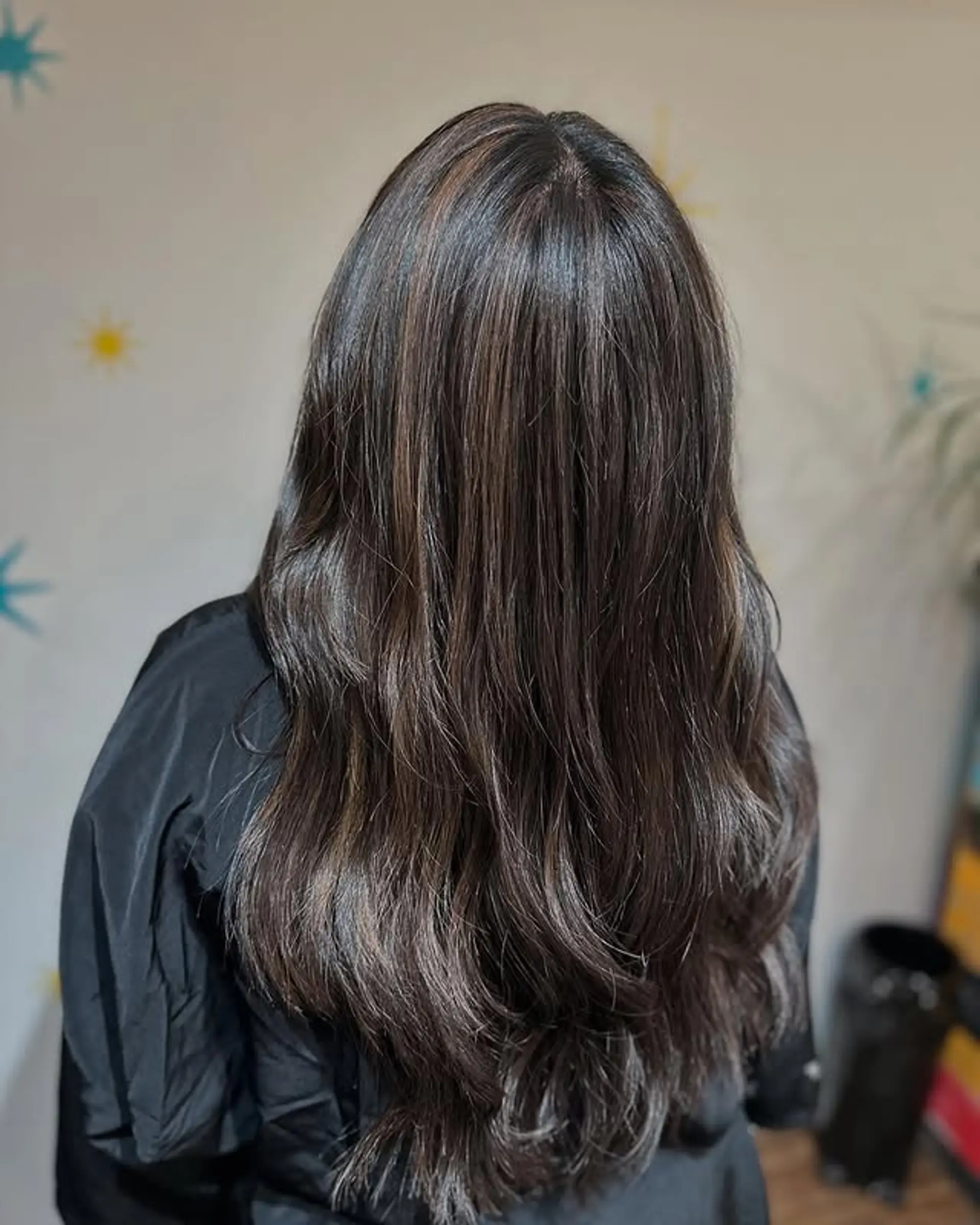 Long layered brunette hair with soft waves and subtle highlights. 1