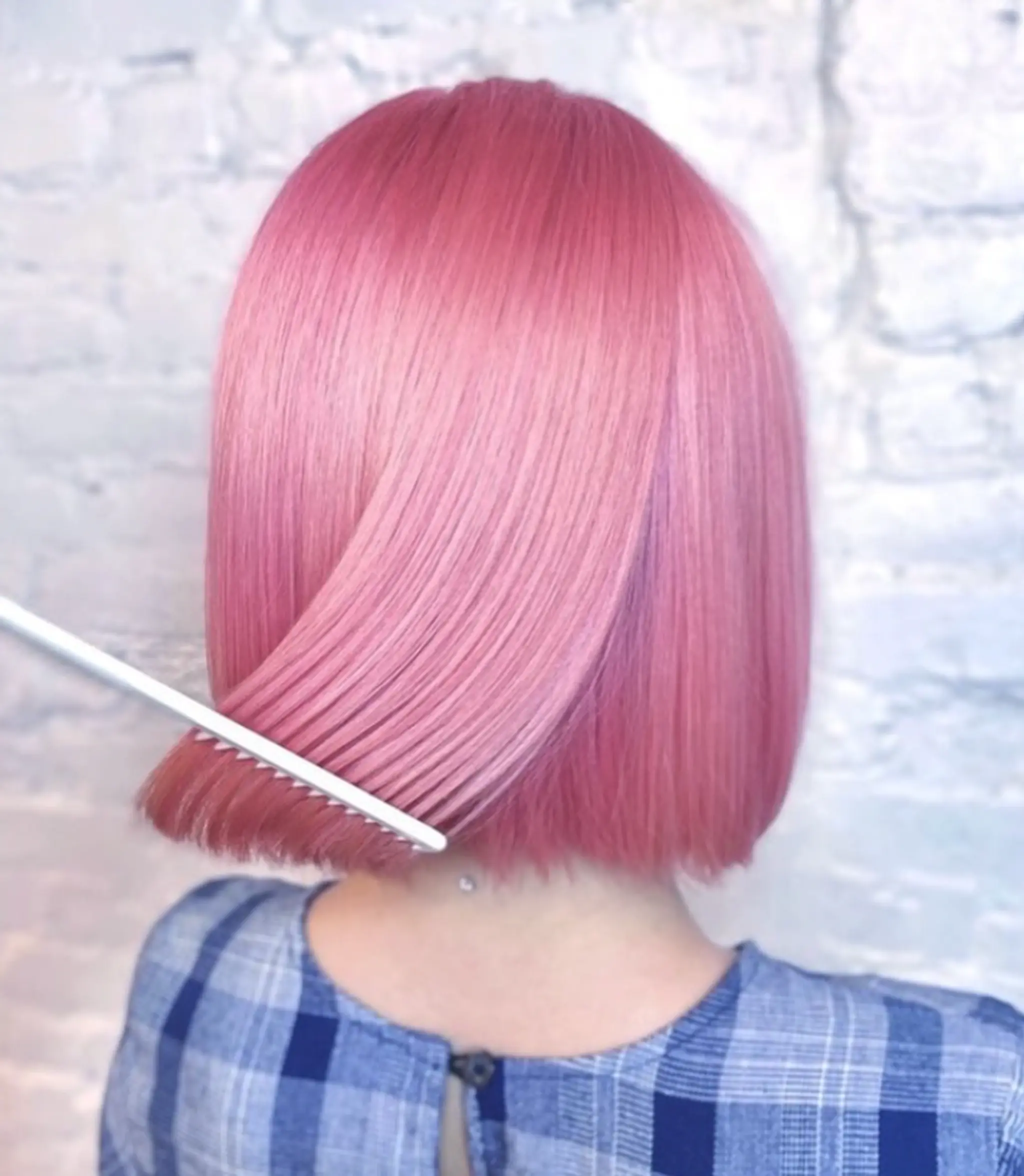 A sleek, straight medium-length bob with a blunt cut, featuring a luminous pink and rose gold color.