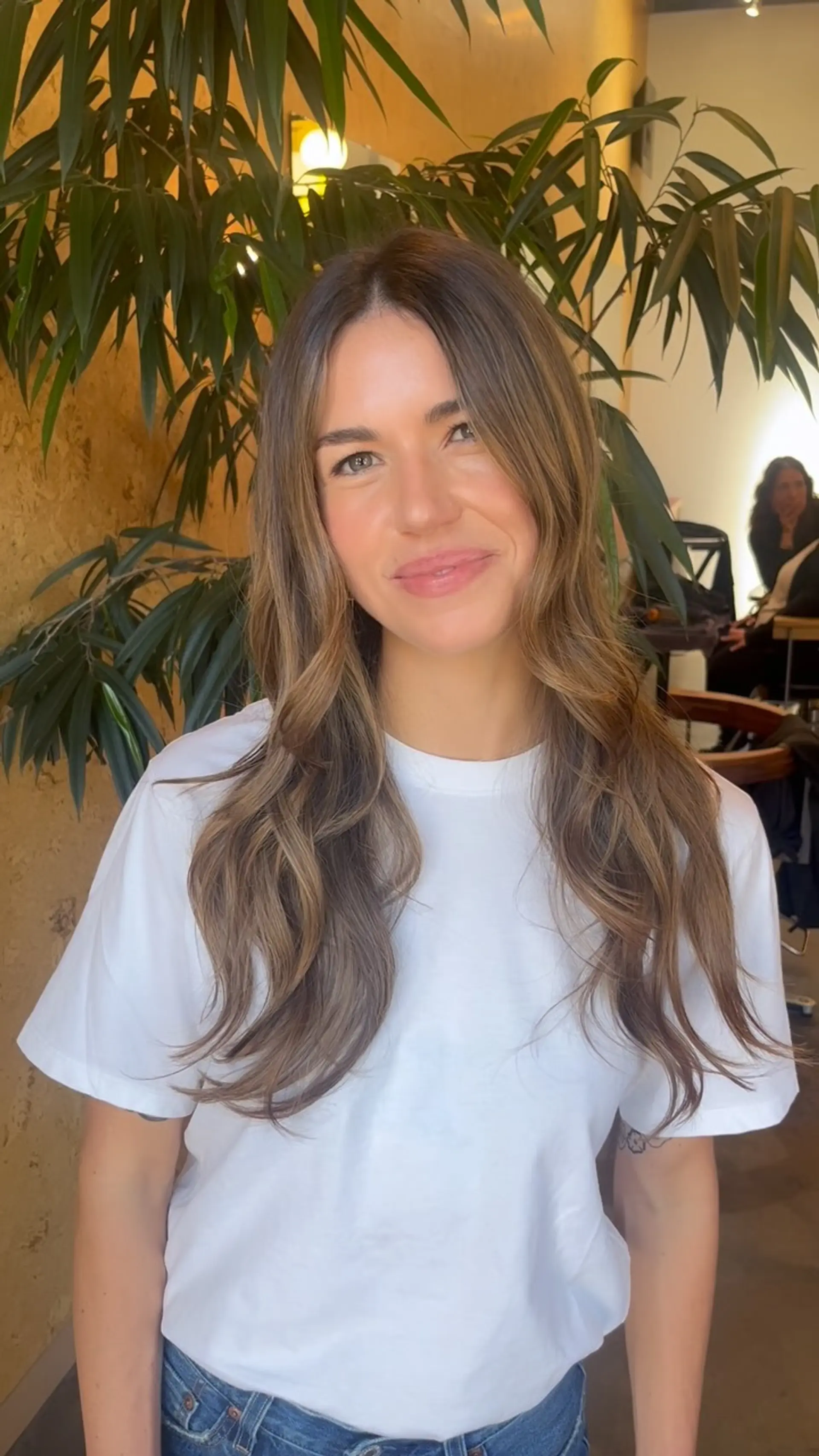 Long brunette hair with soft balayage highlights styled in loose, beachy waves. 1