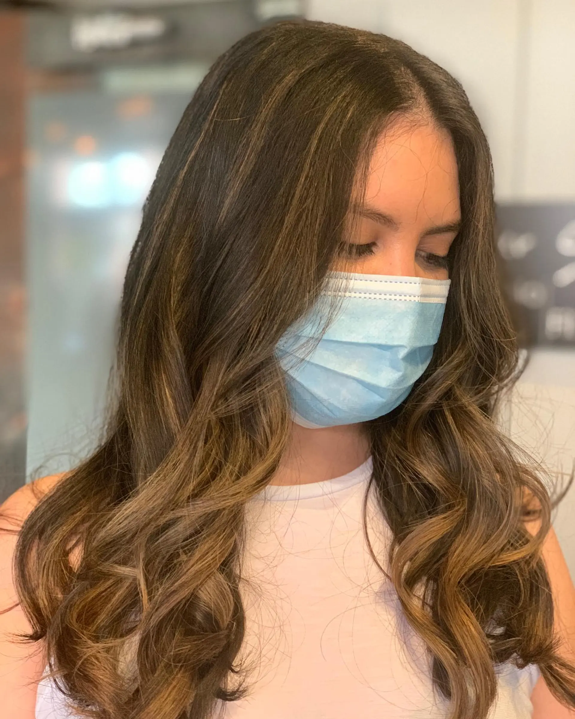 A beautiful, long wavy hairstyle with a bronde balayage. The waves add volume and movement to the hair. 1