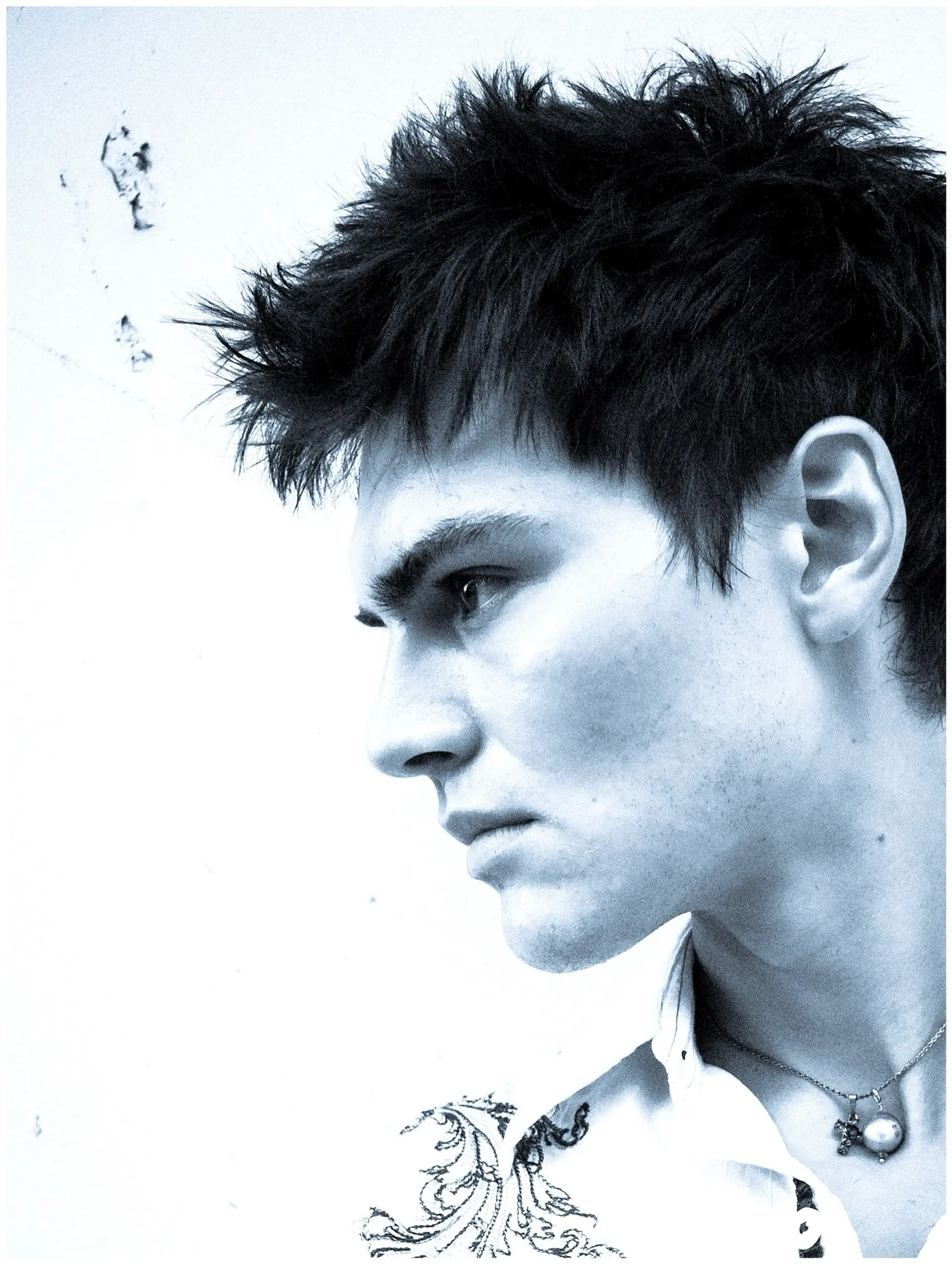 A short, highly textured haircut with spiky styling throughout the top and crown, tapering into the sides and front fringe. 1