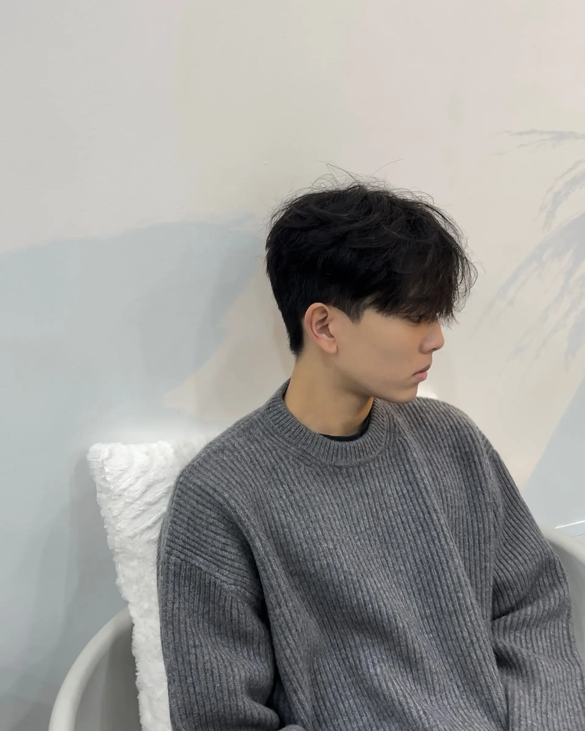 A wavy perm with a textured fringe and tapered sides. 1