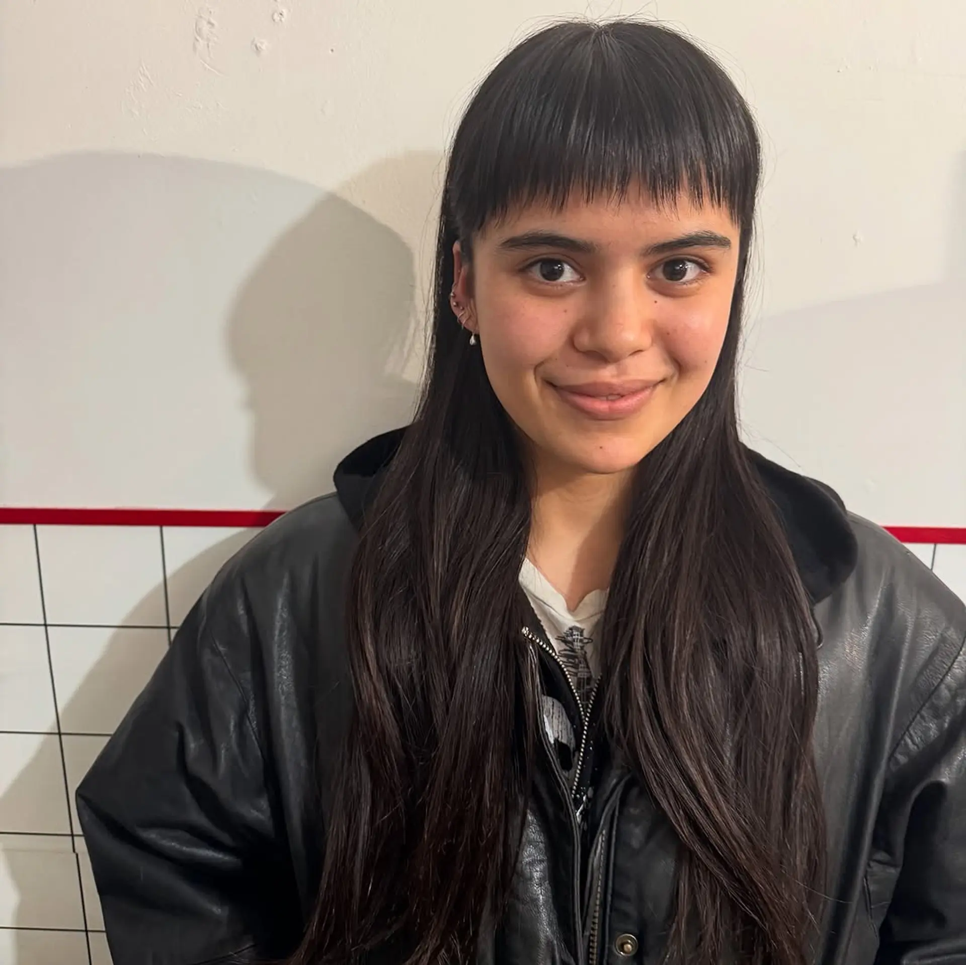 A long, sleek haircut featuring blunt-cut micro bangs that rest well above the eyebrows, providing a high-fashion, alternative look. 1