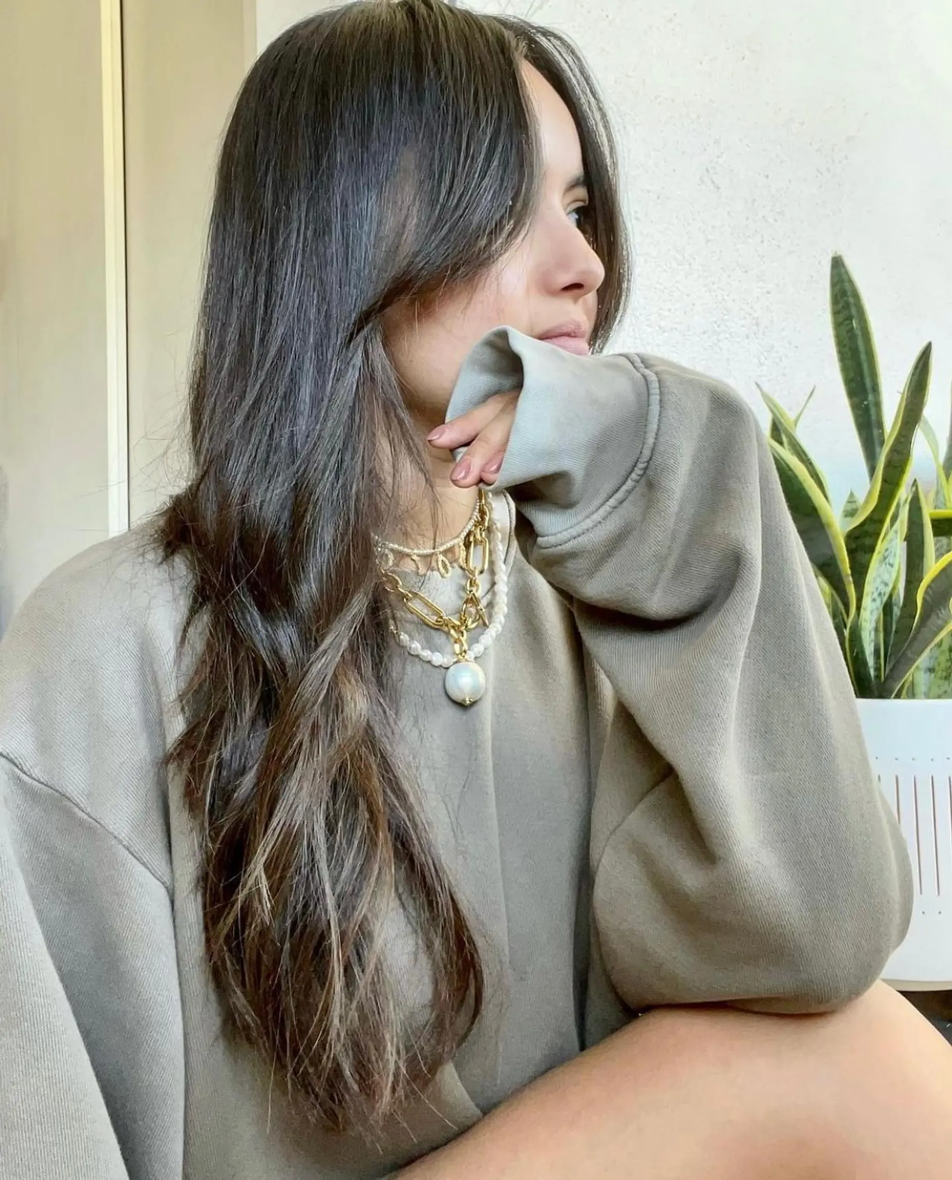 Long layered cool-toned brunette hair styled naturally with soft face-framing curtain bangs. 1