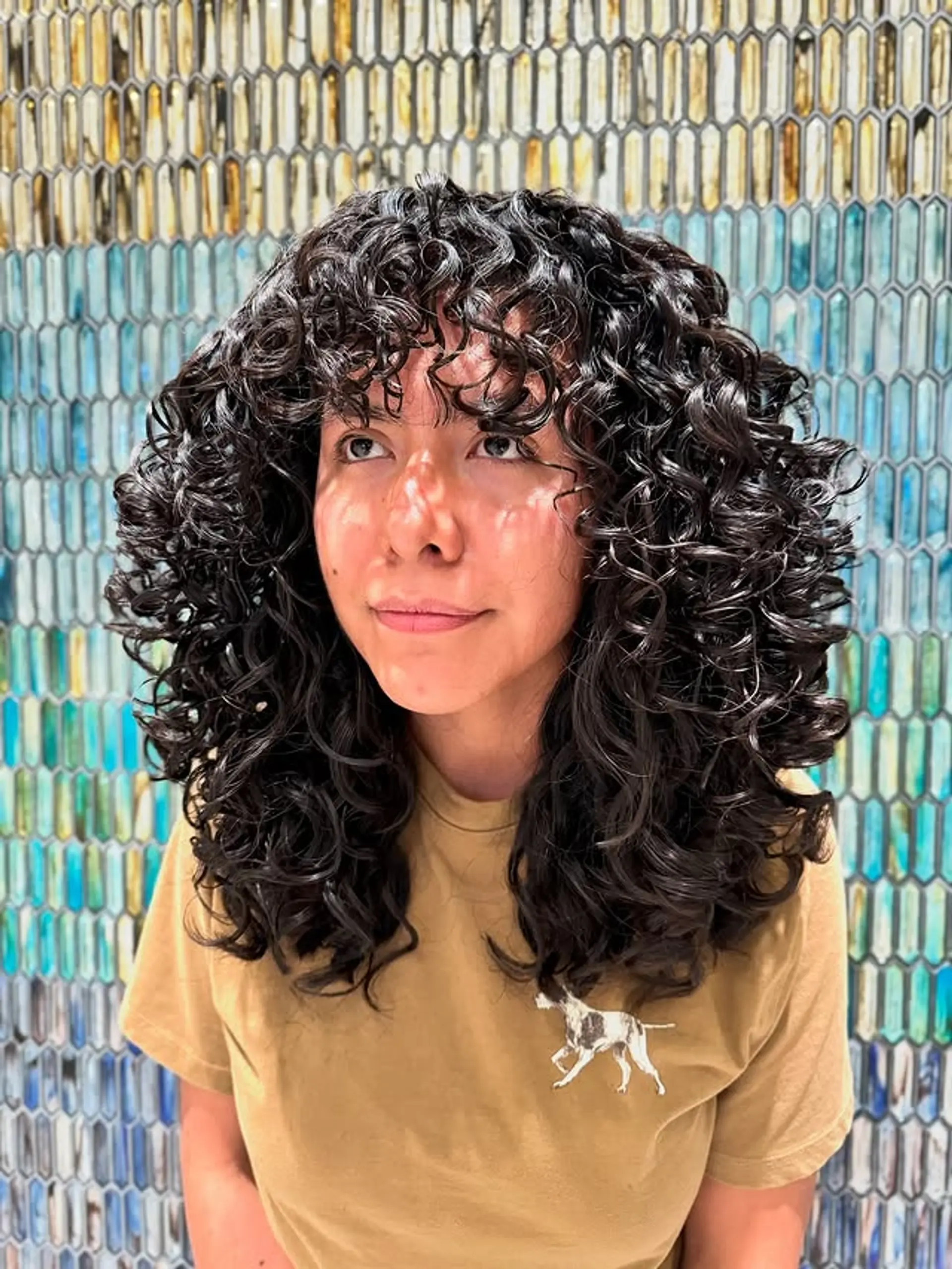 A curly shag with textured layers and full curly bangs. 1