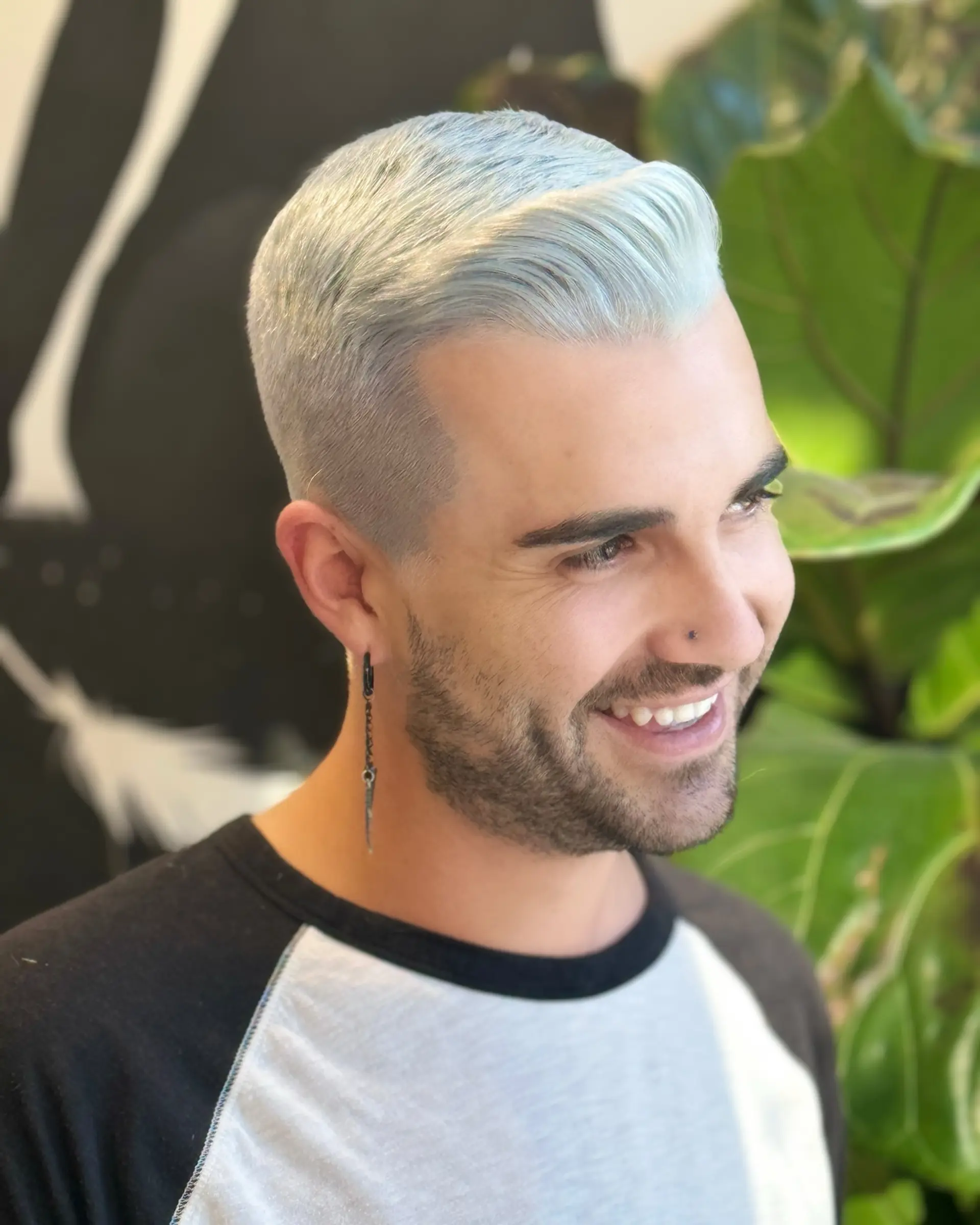 A short, clean fade with longer swept-back textured length on top colored in an icy blue platinum shade. 1