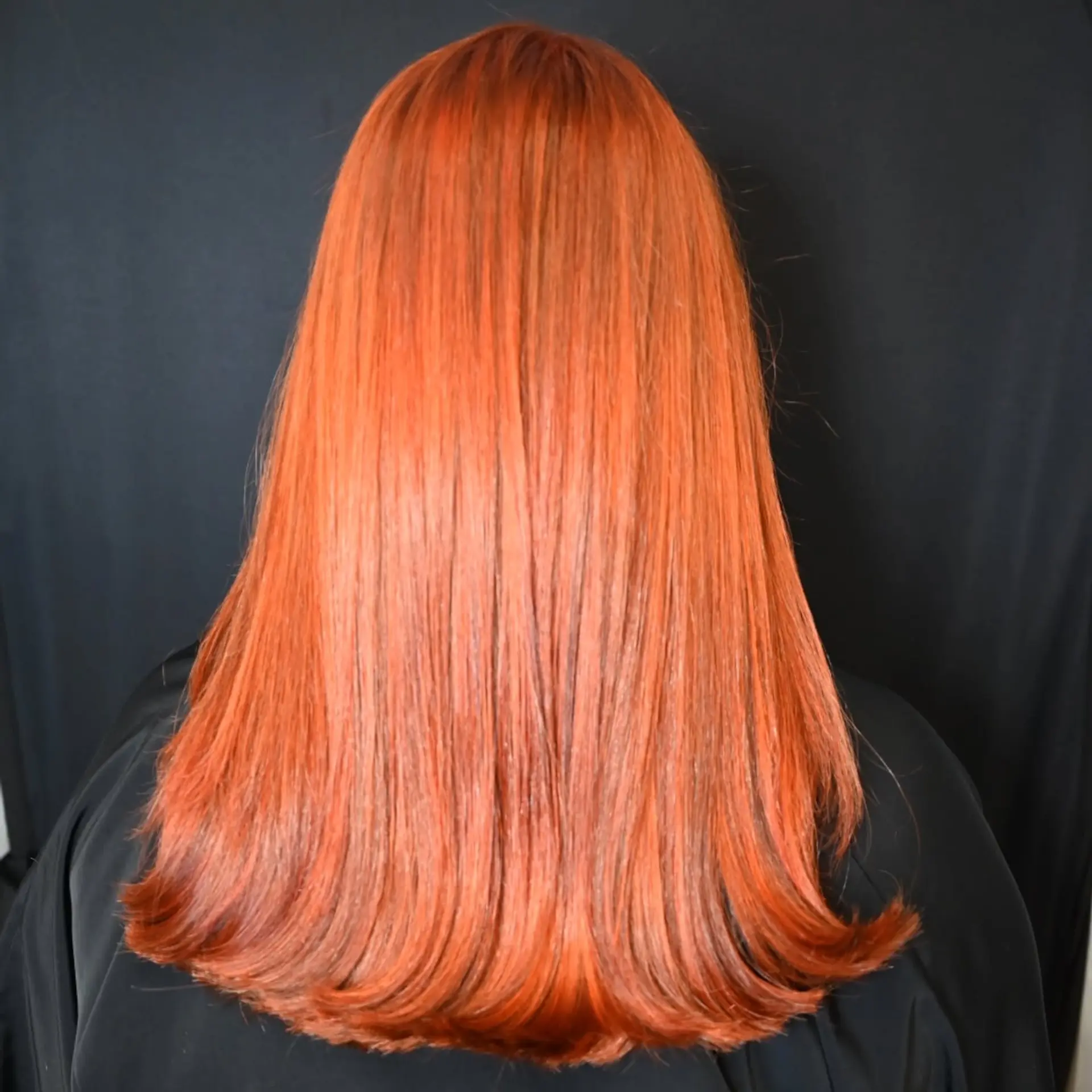 Long, sleek straight hair colored in a brilliant copper shade with rounded ends. 1