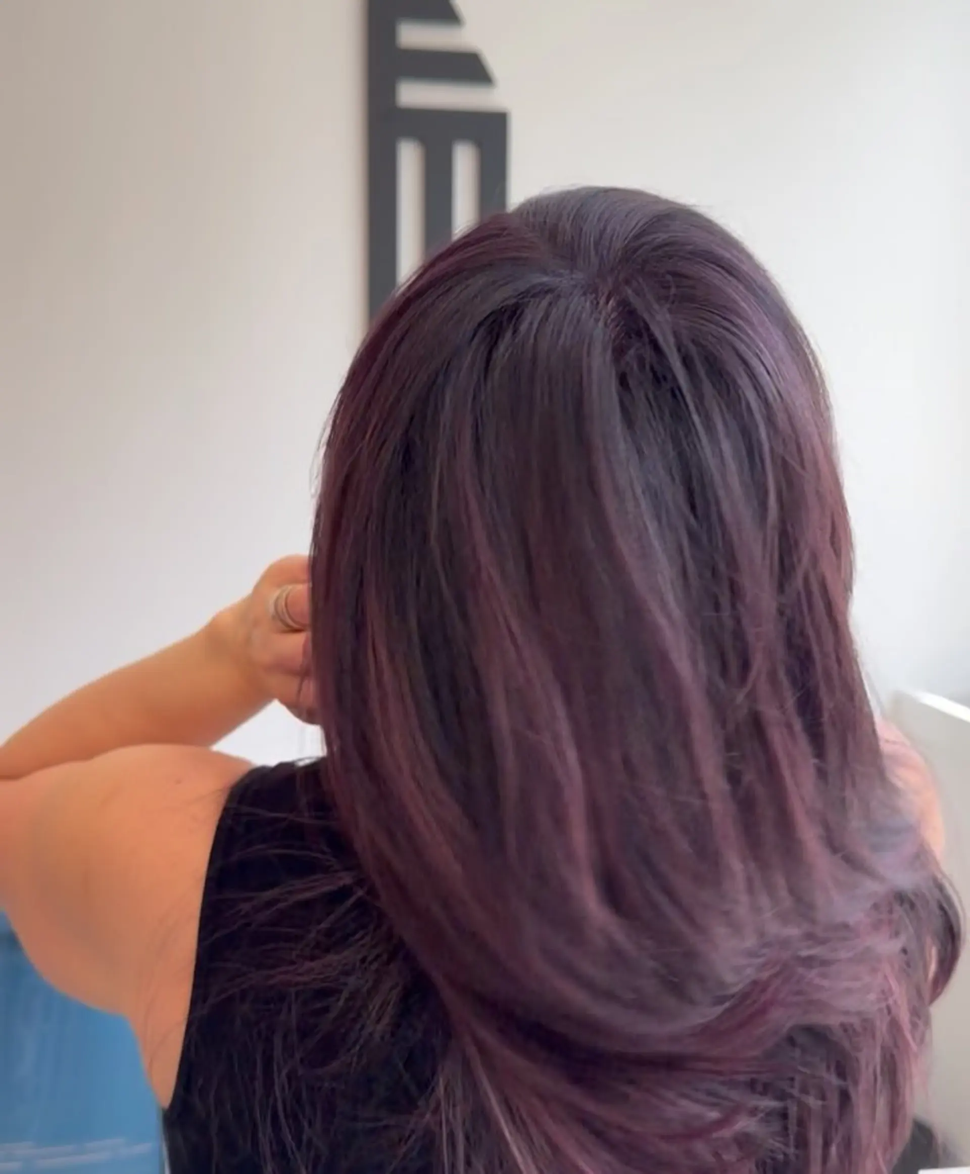 Long layered haircut featuring dark plum purple hair color with smooth styling. 1